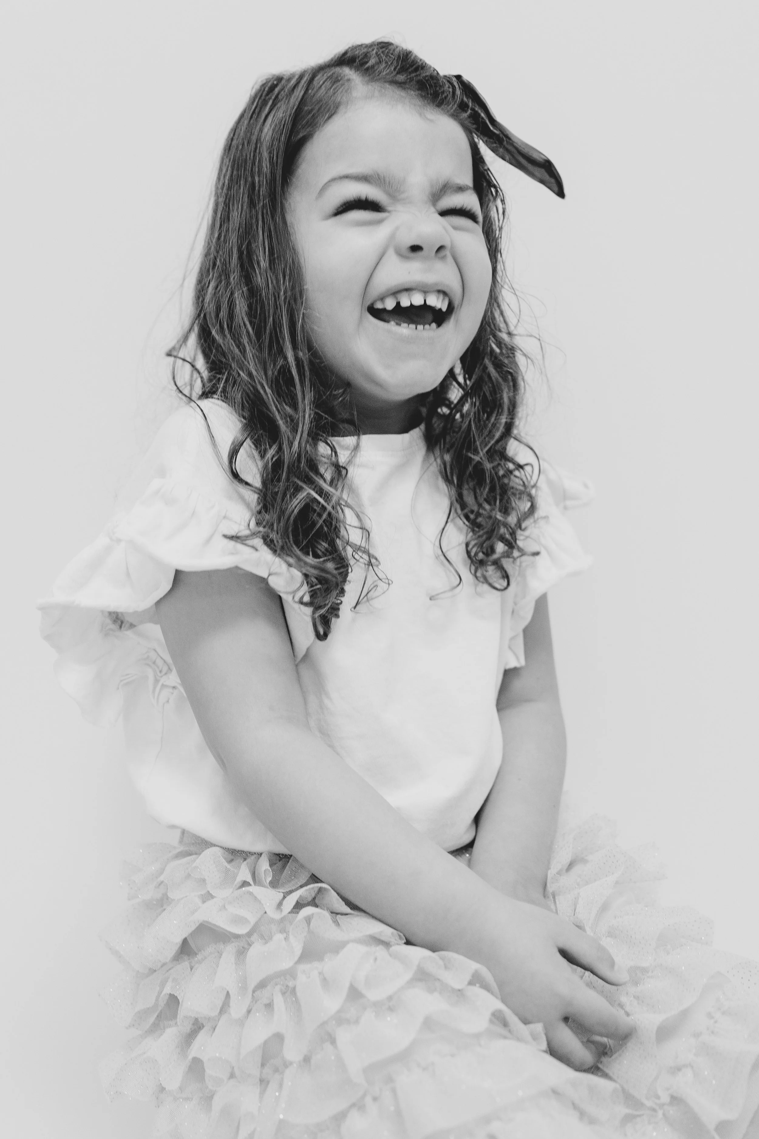 family photo of girl laughing in black and white