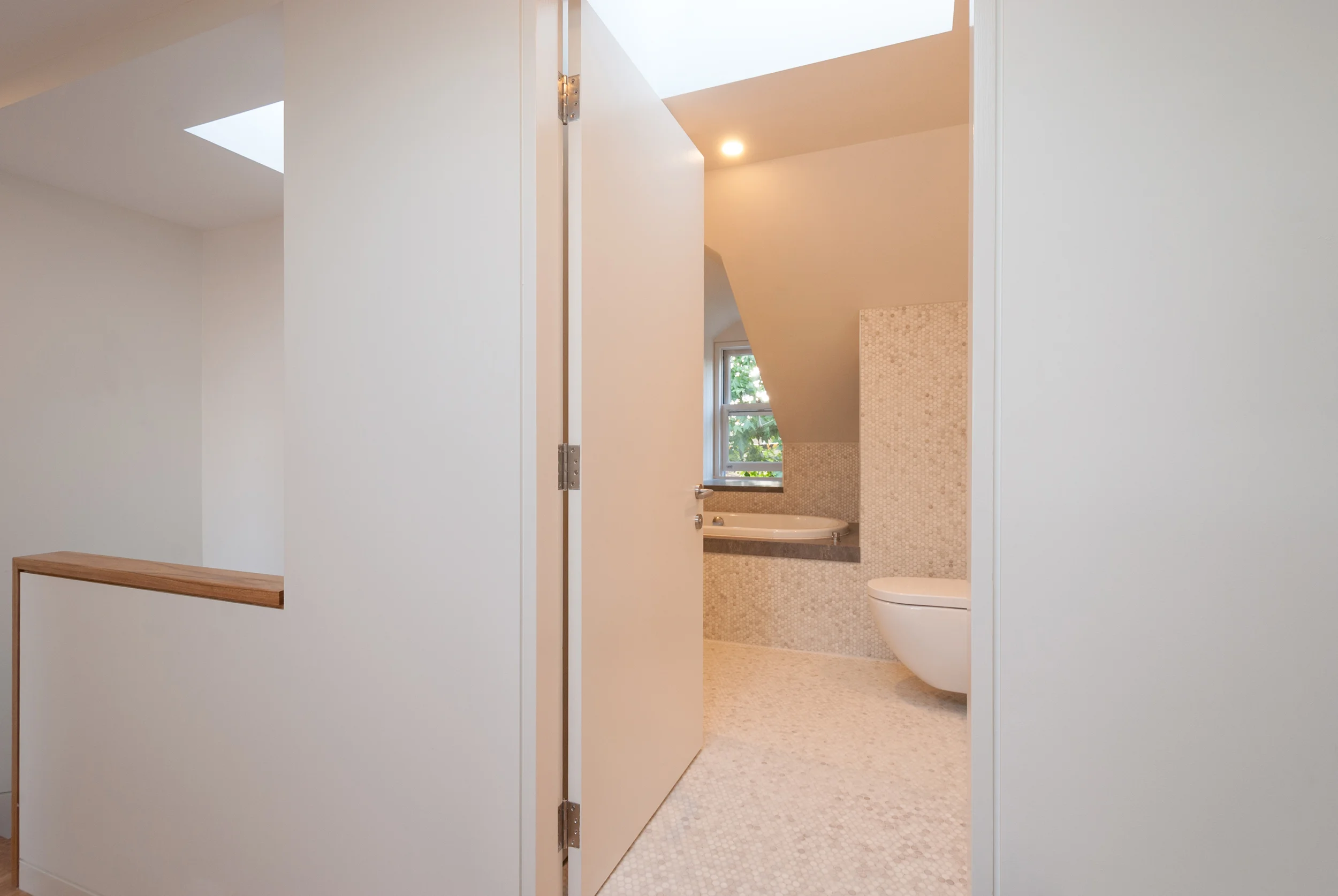 This typical Sydney terrace house in Annandale was in need of a new attic conversion to cater for a growing family. The old pull down attic ladder was swapped out for a new solid timber stair, the pocky attic storage space was converted to a new bathroom and a study and bedroom as added to the rear of the first floor. With a focus on grabbing light and ventilation wherever possible, the new spaces slot in over the old house and behind the original slate roof. A new dormer over the bath to the street frontage provides lovely glimpses through to the canopy of the street trees.