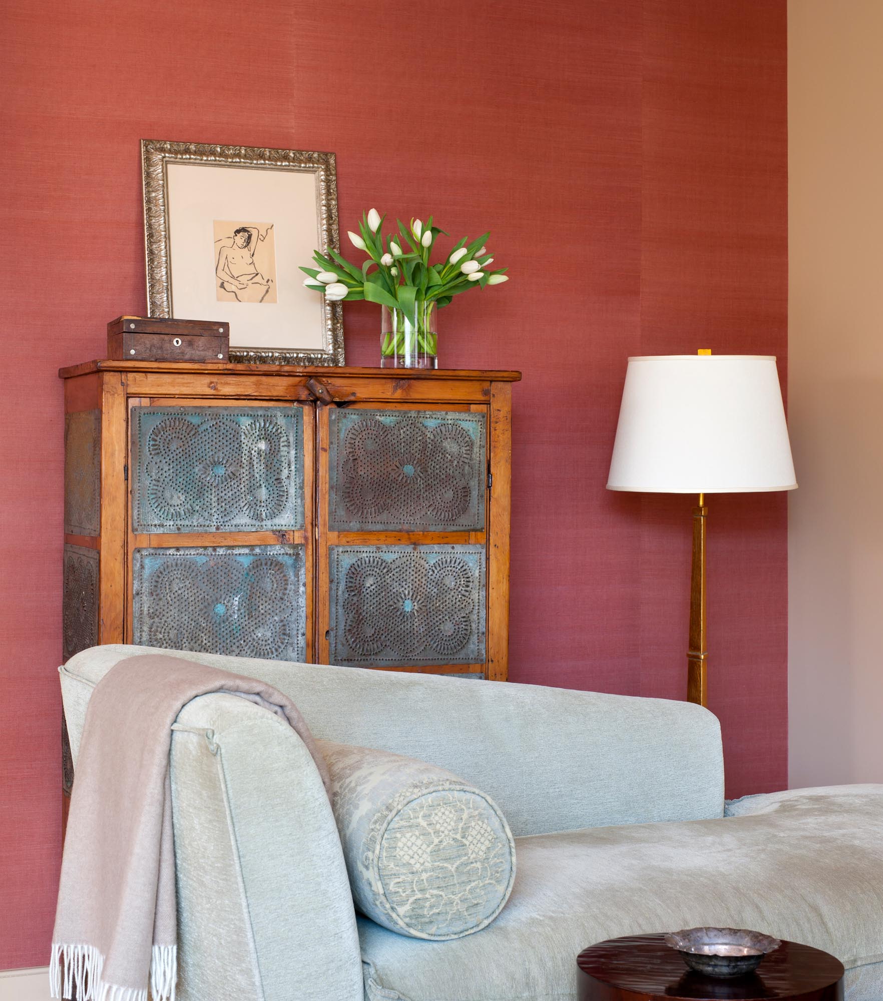 Cabinet with decorations on top, sofa day bed and floor lamp in a modern living room design