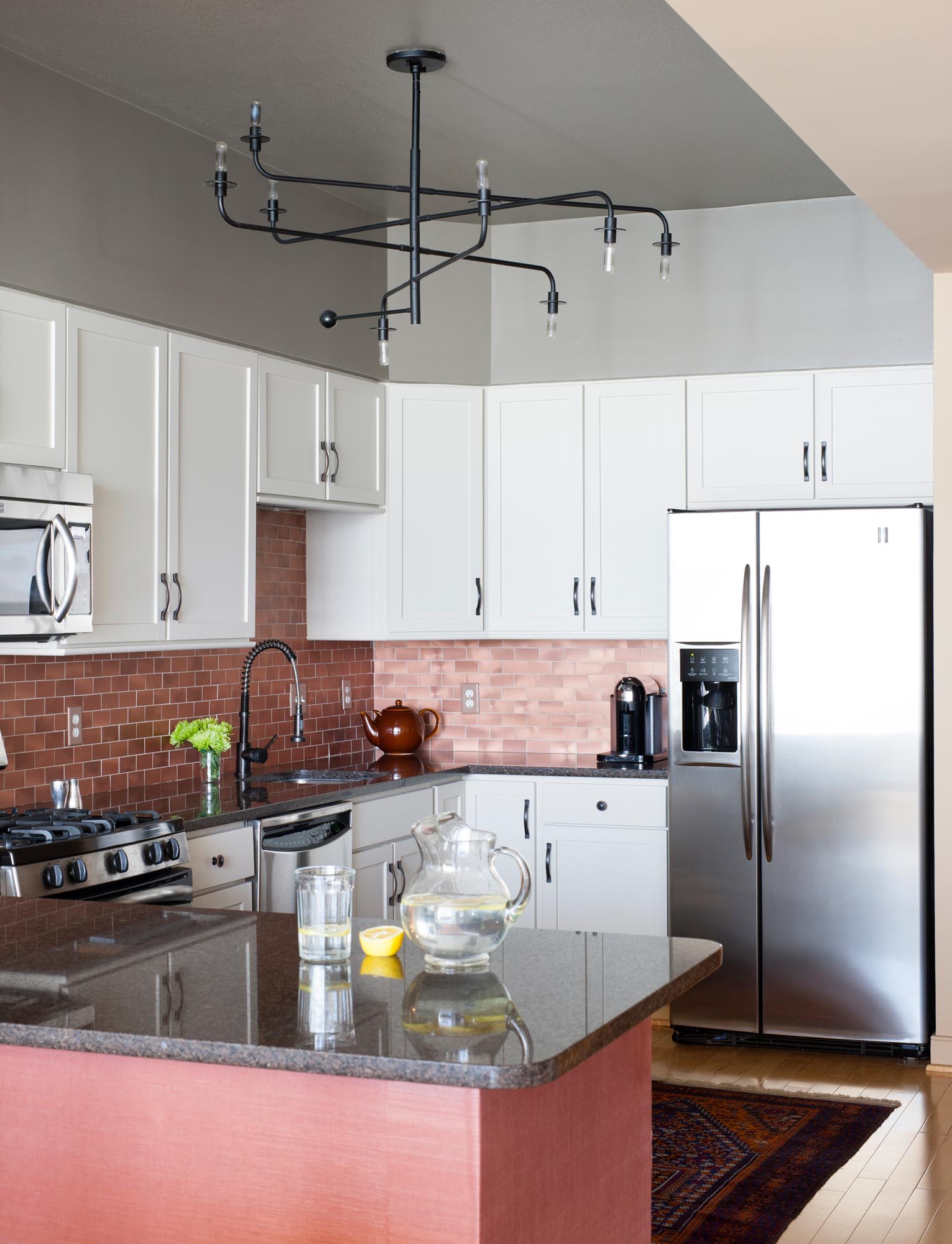 Modern Kitchen Interior with stainless steel appliances, white cabinets and granite counter top.