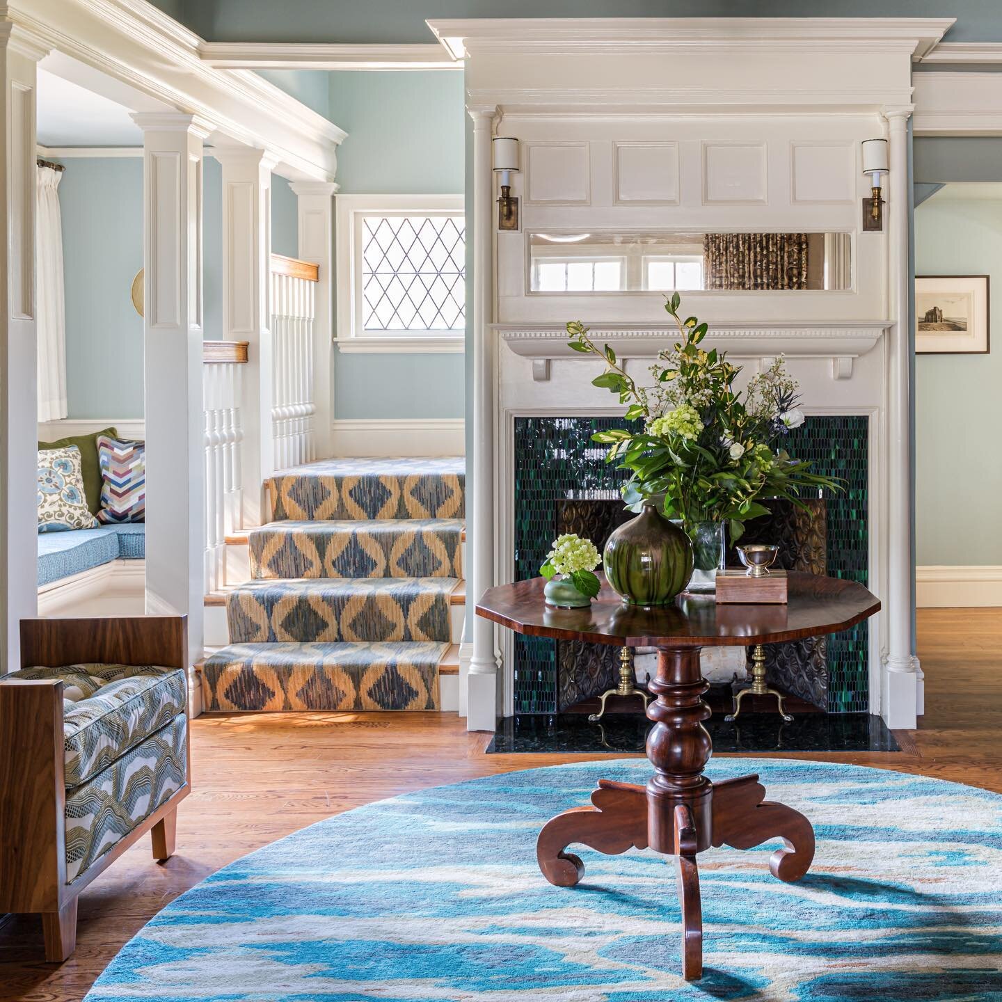 &quot;What I love most about this foyer is the fireplace facade, which was updated with an elongated hexagonal patterned glass tile in peacock blue and emerald hues,&quot; says Austin. Though the unexpected palette is an instant eye-catcher, the star