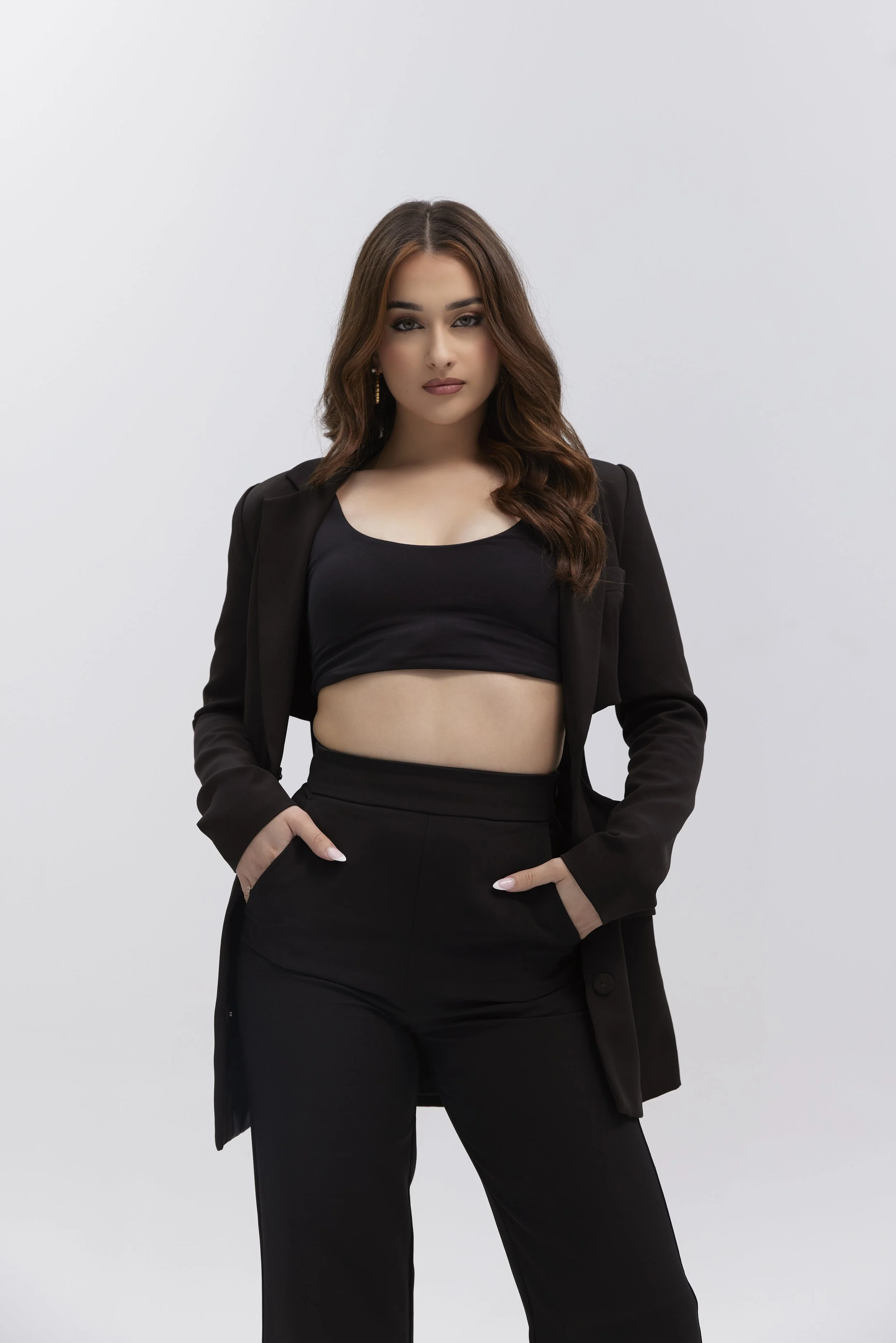 Headshot of a woman with natural makeup, smiling in a studio, wearing a black top blazer model workshop model london