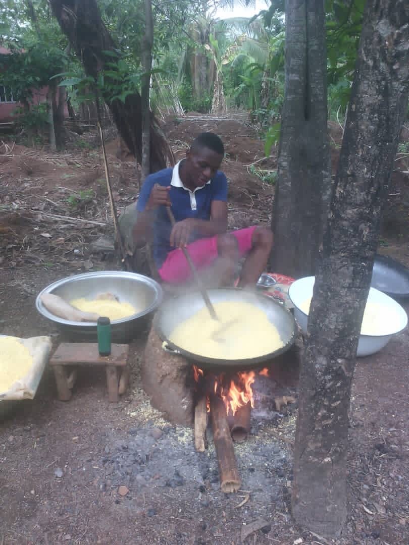 Helping his mom to process cassava into garri, a Nigerian staple food.