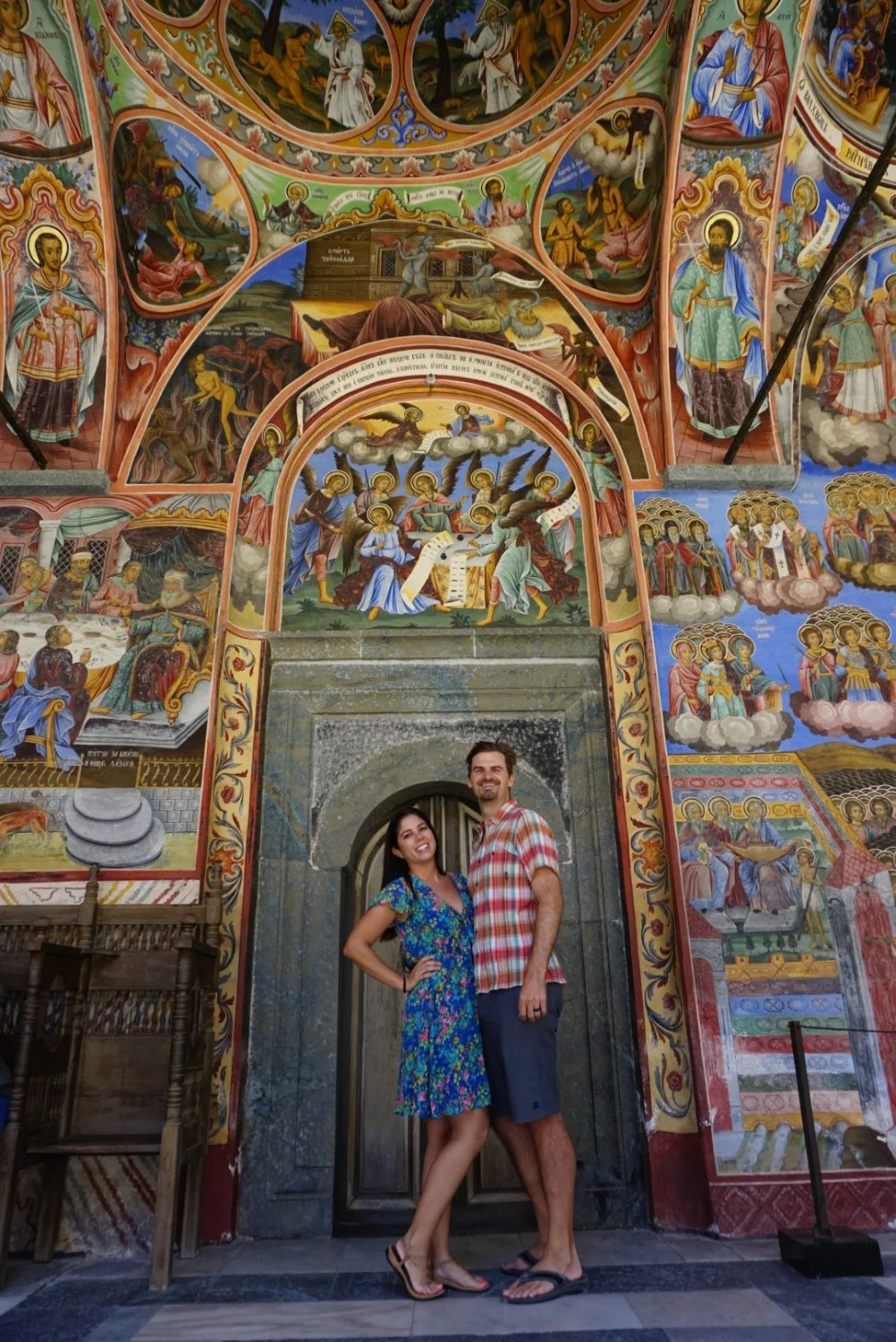 Kelly and Matt of Boldly Go Travel pose for a picture at the beautiful Rila Monastery in Bulgaria.