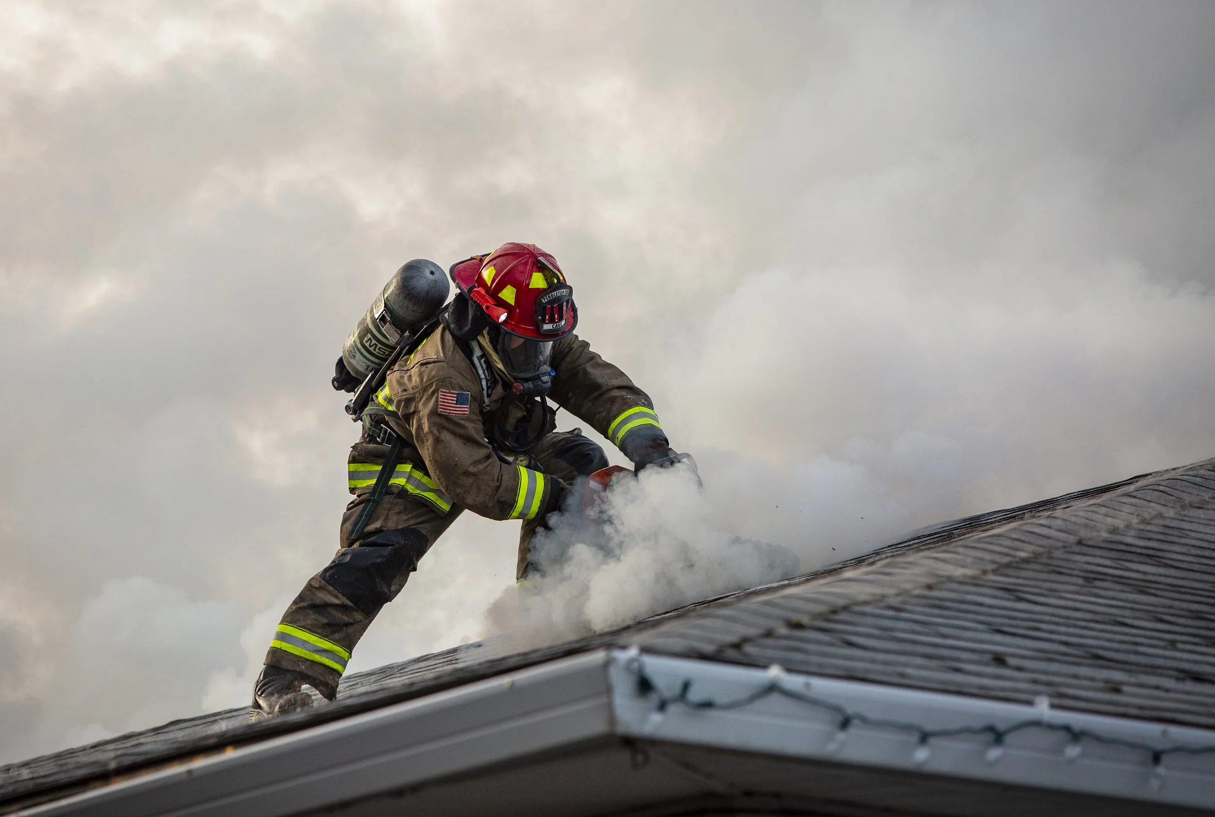  A firefighter cuts a vent into the roof of a house Saturday, Jan. 8, 2022, while working to extinguish a structure fire at 809 S.W. Sixth St., Pendleton. 