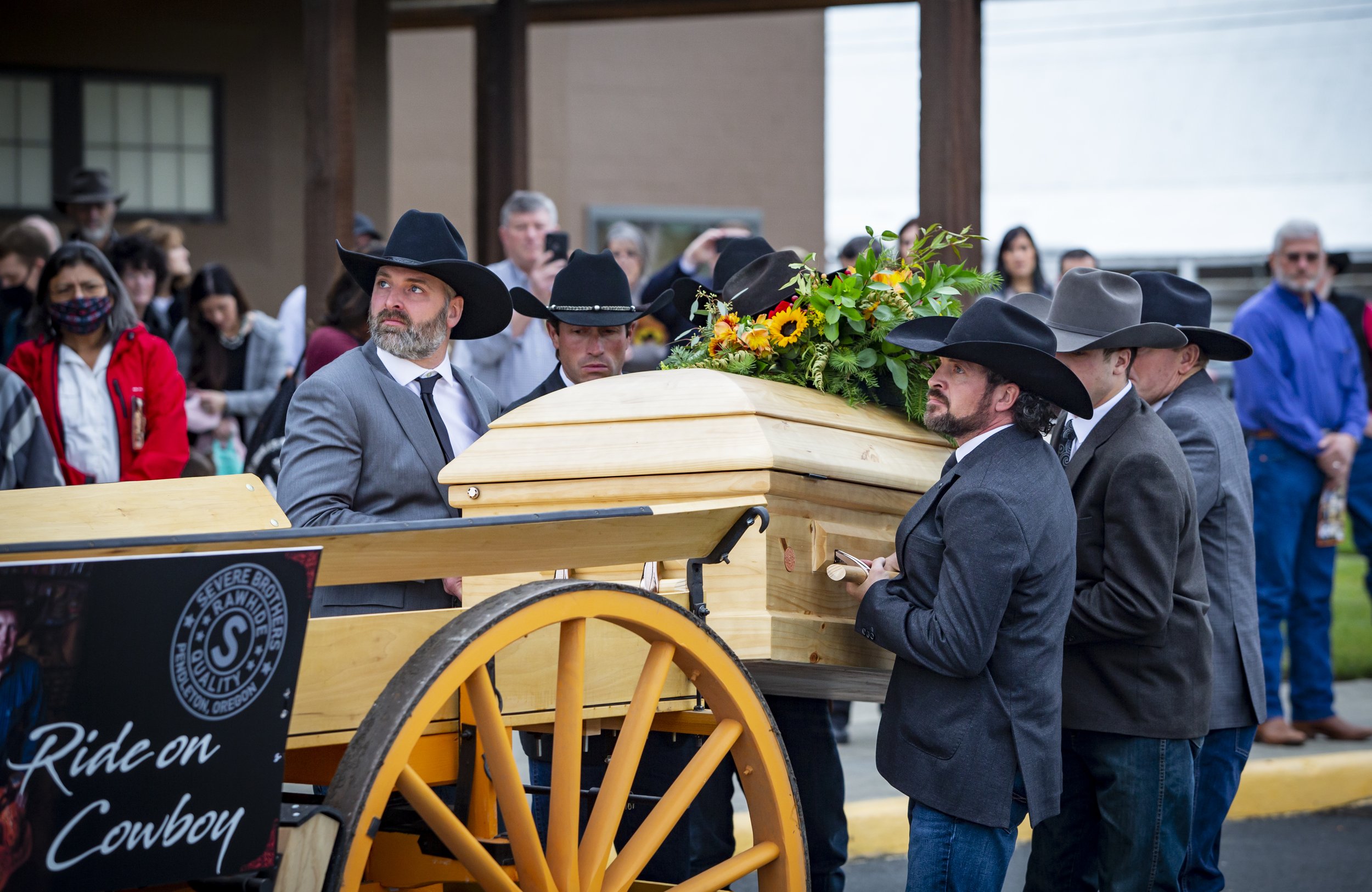  Randy Severe’s sons Ryan Severe, left, and Jarad Severe look up as they load their father’s casket atop a horse-drawn carriage Tuesday, Nov. 30, 2021, following his funeral service at the Pendleton Convention Center. 