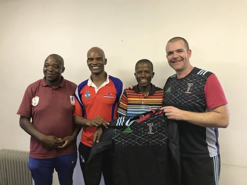 Marc from Harlequins Foundation presenting a Harlequins training top to Molife, one of our new coaches