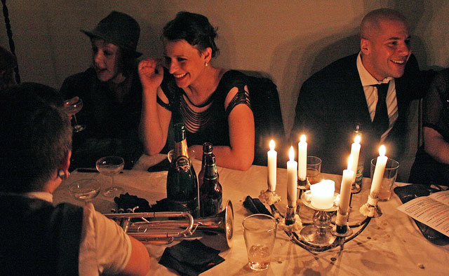 Guests at a dinner table with a trumpet