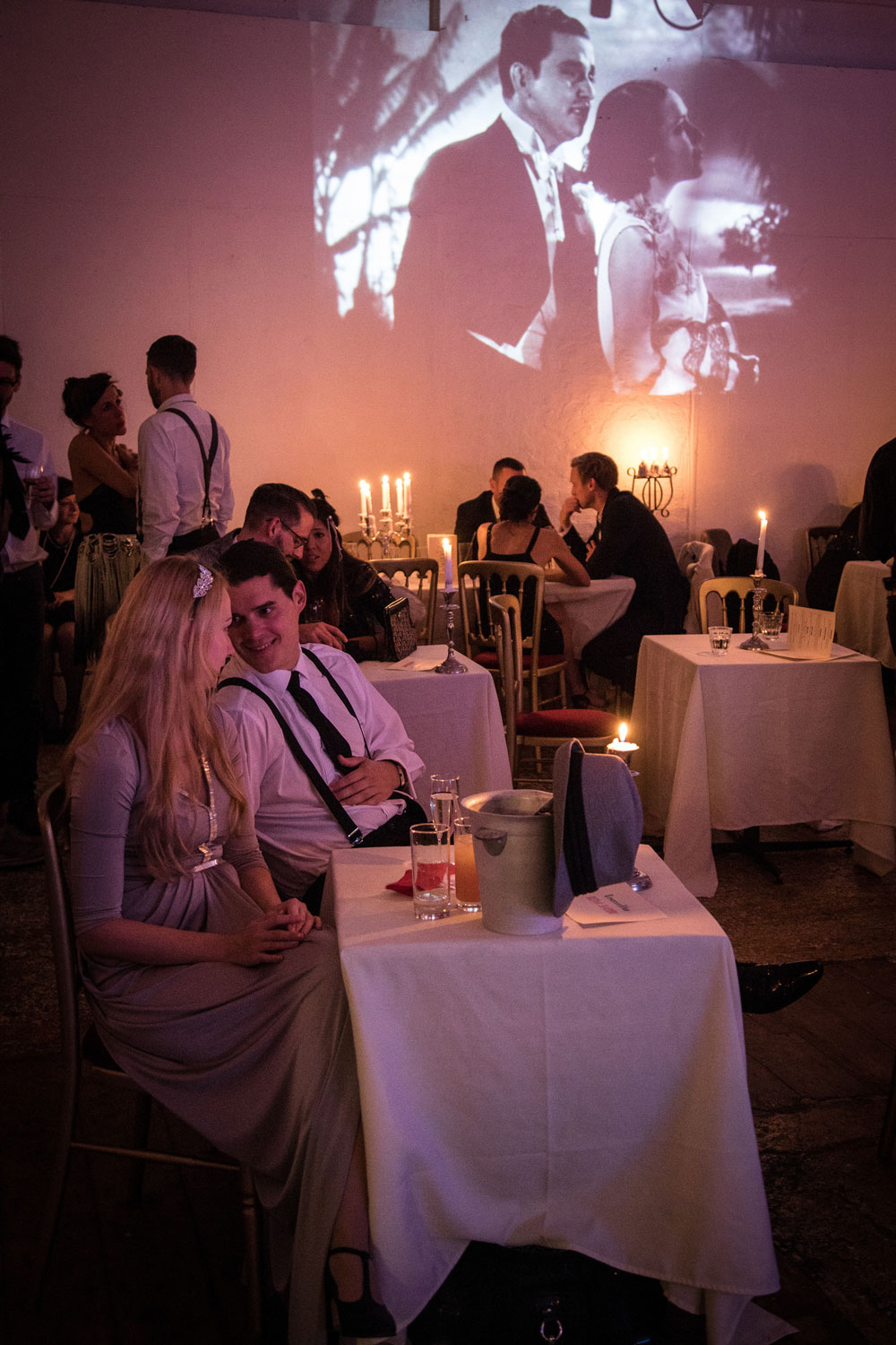 Couple at a dinner table with movie projection in the background