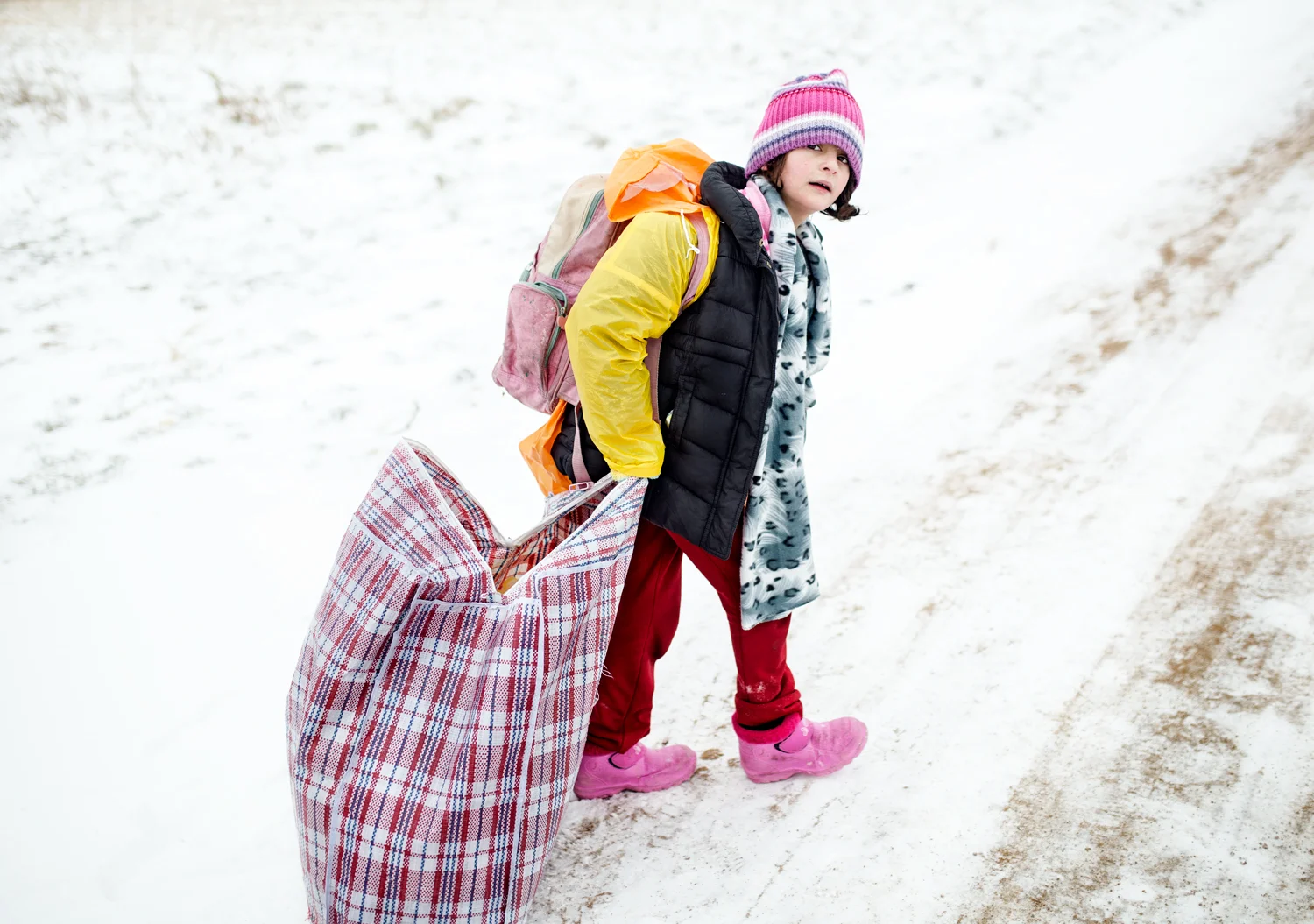  A Syrian girl drags her belongings along the way from Miratovac to Presevo, Macedonian-Serbian border, January 2016. Since last winter Europol has reported the disappearance of at least ten thousand refugee children traveling alone in European terri
