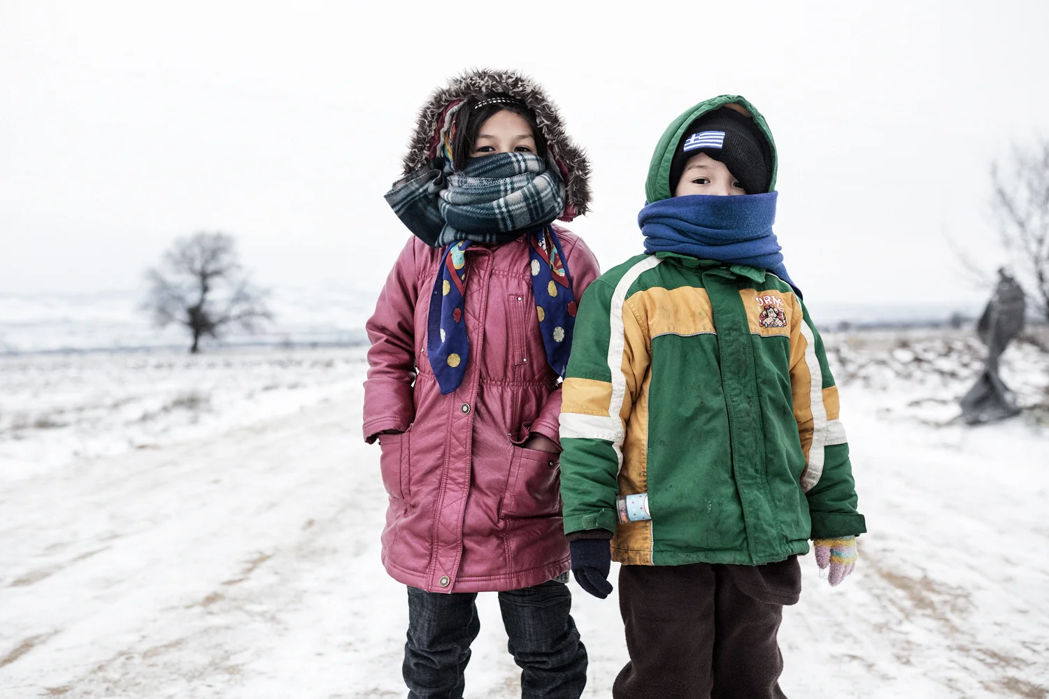  Two Afghan siblings pose on the way from Miratovac to Presevo, Macedonian-Serbian border, January 2016. Last winter the provision of winter clothes and hot food were the main priorities for humanitarian organizations. 