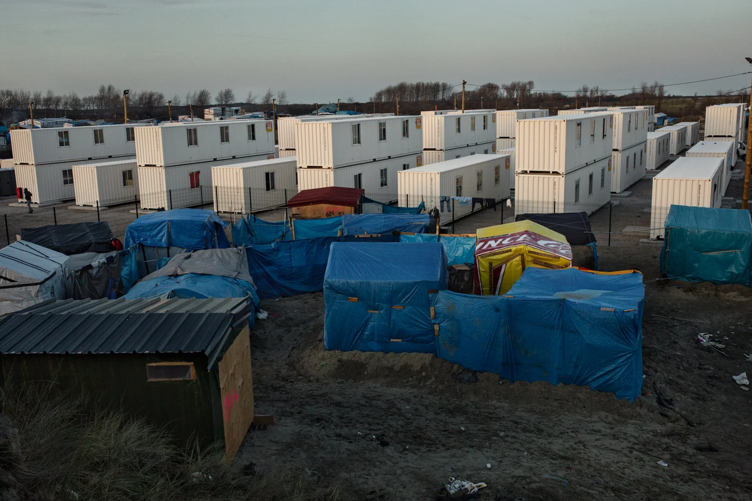  Containers and shacks form the landscape of the Calais Jungle, France, March 2016. Since February 2016 the French government has been dismantling areas of the settlement in order to relocate refugees and migrants against their will in more controlle