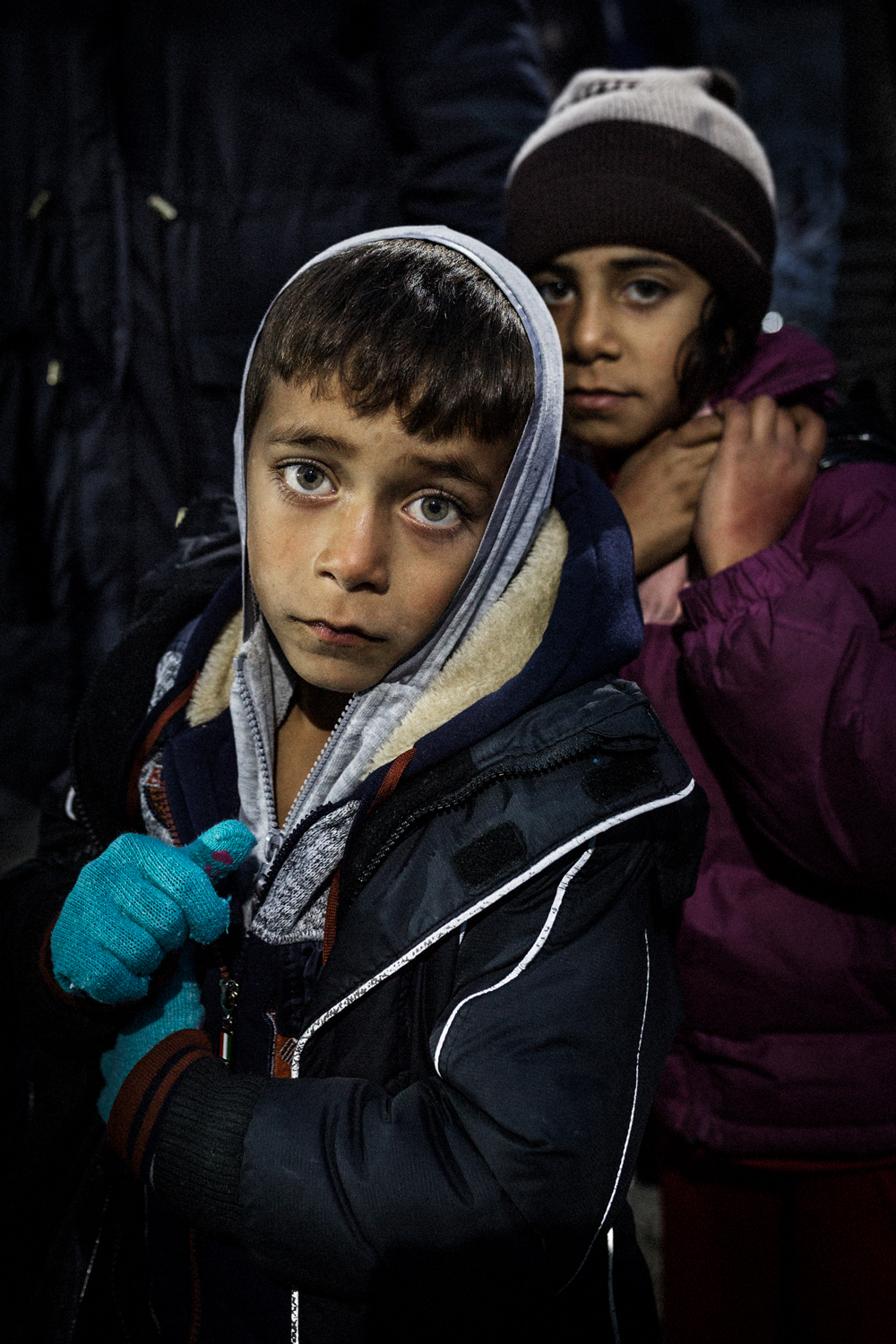  A Syrian child waits together his sister for the opening of the border pass between Greece and Macedonia, January 2016. 
