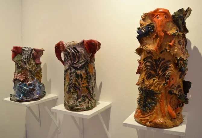 HYPERALLERGIC: Ceramics Stage a Coup at NADA Miami Beach 2016: Typically a stronghold of painting, the NADA Miami Beach fair is awash in clay sculpture this year. By Benjamin Sutton DECEMBER 2016 MIAMI BEACH — The idea that ceramics are making a comeback in the art world and the art market is not exactly news. Regular visitors to Chelsea and other blue chip gallery districts and members of the global art fair jet set have seen clay and porcelain steadily gaining ground on paint, ink, and more conventional sculptural materials like bronze. And this year, ceramic art has made major inroads at NADA’s Miami Beach fair, a quintessential bastion of painting. (Textiles, too, are on the rise, both at NADA and Art Basel Miami Beach.) Ranging in style from finish fetish works in the lineage of Ken Price and Ron Nagle, to playful figurative statues and imaginative riffs on traditional ceramic objects like vases, this year’s NADA fair feels like a potter’s paradise. My personal favorites, presiding over the booth of New York’s Rachel Uffner Gallery, are Sally Saul’s sculptures of two female figures, a dog, a fox, and a flower. The curious grouping is a testament to her endearing and playful iconography, and revived my desire for a big solo show of Saul’s sculptures — word is that Uffner has one in the works. The fair features works by several artists working in the same vein as Saul — that is, making figurative ceramic work that plays with scale and tone, or that uses the handcrafted medium to imbue typically inanimate objects with inner life. Two shining examples of this approach are the playful food sculptures by Valerie Hegarty that are on view in Miami gallery Locust Projects‘ booth, and the cryptic, almost grotesque head sculptures by Jennie Jieun Lee that New York’s Martos Gallery is showing. Several ceramicists featured at NADA Miami Beach took a more deconstructive approach to figurative shapes and images. Bruce M. Sherman‘s two works in New York gallery Nicelle Beauchene‘s booth feature human forms that have been fragmented into disjointed planes in a quasi-Cubist manner (“Woman with Fish,” 2016) or radically reduced to stubby limbs and little else (“Equi Lib Reeum,” 2016). Puerto Rican artist Cristina Tufiño takes a different approach in her ceramic works in the booth of San Juan’s Galería Agustina Ferreyra. The works mimic the forms of conventional vases while also evoking certain body parts — the face, the torso, the hips — streamlined to a few telltale features. Nearby, the mezzanine booth of Brussels gallery Sorry We’re Closed features a set of tabletop works and one tower of ceramic heads by Eric Croes. The pieces’ cartoon-like forms and vibrant glazes are delightful. Amid the riffs on conventional ceramic vessels, the standouts are the dozens by Los Angeles-based painter Roger Herman filling the walls and shelves in the booth of Paris gallery Lefebvre & Fils. Ranging from pitchers and vases to bowls and plates, many feature figurative images, from deathly skulls to grimacing figures. Around the corner, in the small booth of New York gallery Situations, three large vases by outsider artist Jerry the Marble Faun seem to burst with exotic flaura and fauna. Finally, for those who prefer their ceramics more firmly in the lineage of minimalism and geometric abstraction, two standouts are Zachary Leener‘s psychedelic work in the booth of Los Angeles gallery Tif Sigfrids — which evokes a cactus or perhaps a key to an alternate reality — and Peter Shire‘s small work in the Derek Eller Gallery booth — which could almost be a maquette for the next starchitect-designed Miami Beach resort. Seen in the context of NADA Miami Beach’s longtime home, the charmingly old-school Deauville Beach Resort, these two works in particular stand out as alluring visions from a ceramic-filled future.
