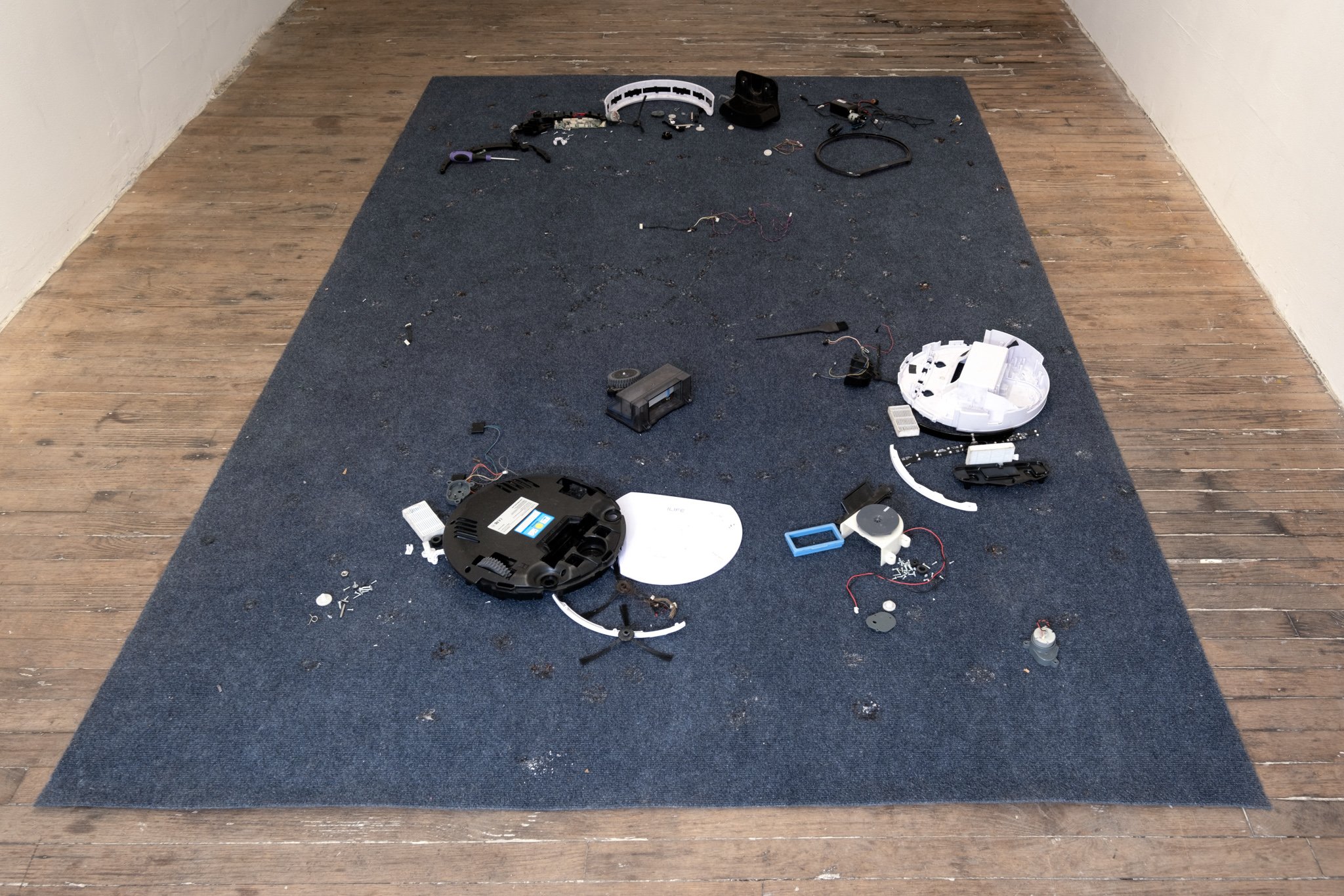  Xenia Bond  Cannibalised robot , 2022 Carpet, cigarette burns, robot vacuum, screwdriver 101.5 x 64 inches (258 x 163 cm) 