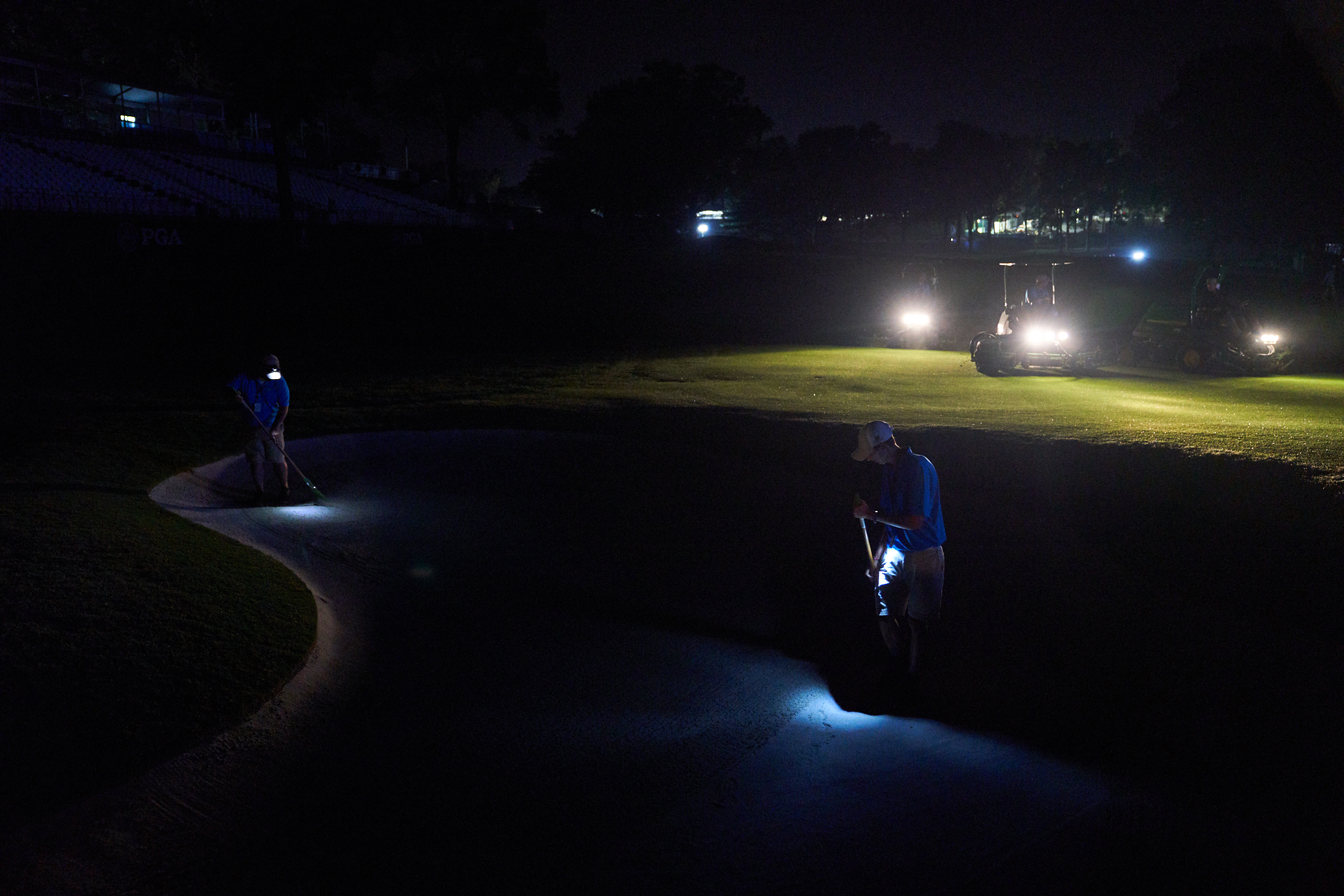 Members of the maintenance staff tend to a bunker at the 18th early in the morning before round two.. (Sony A9, Sony 24-70mm f2.8 G-Master)