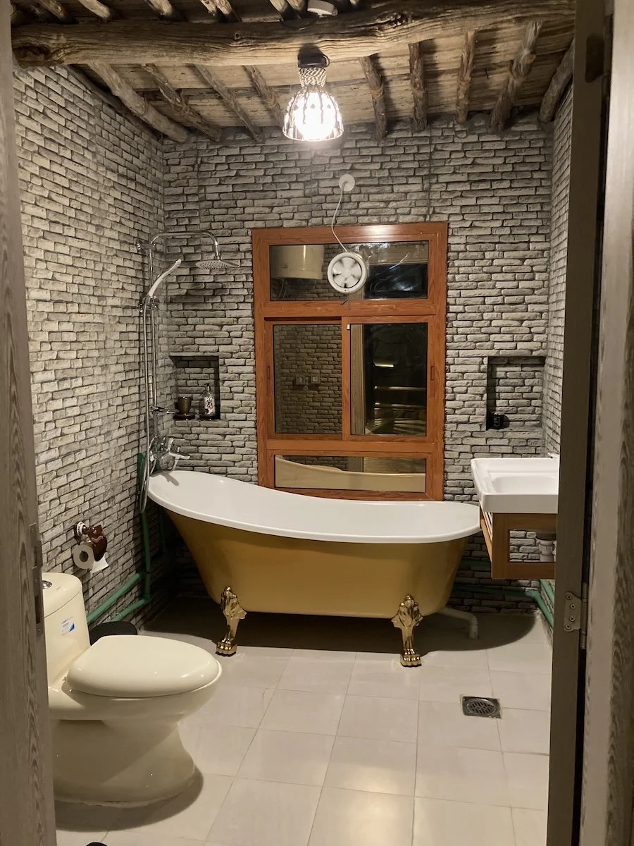 Bathroom with stone walls and lion-claw bathtub