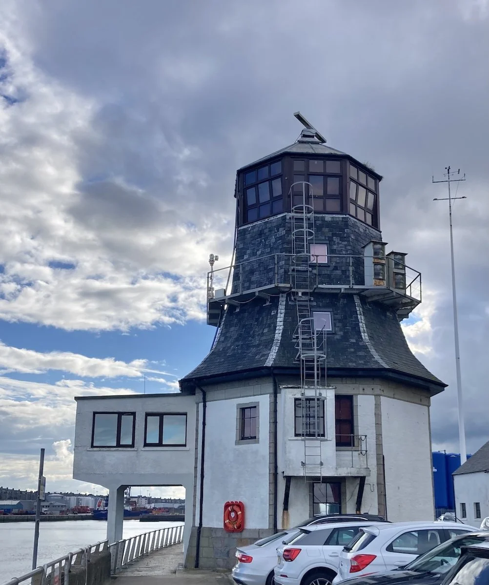 Old lighthouse with cars parked in front