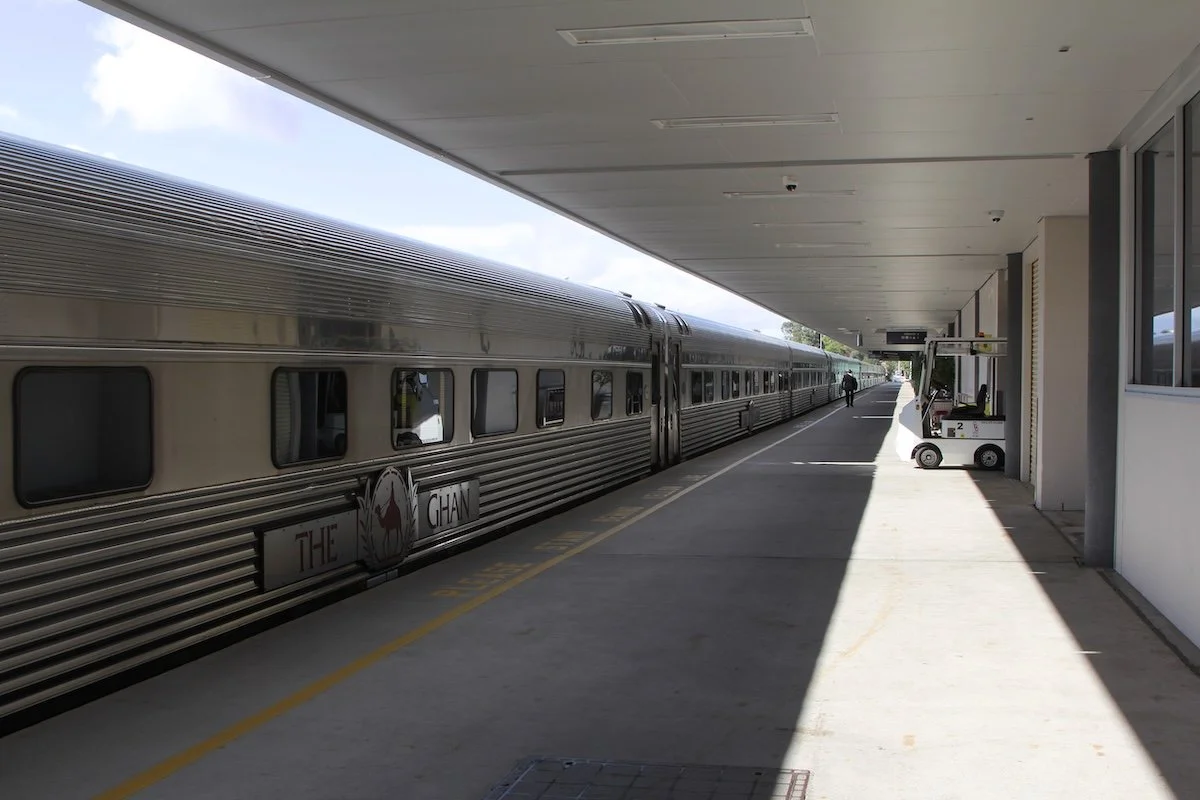 long grey train at empty platform