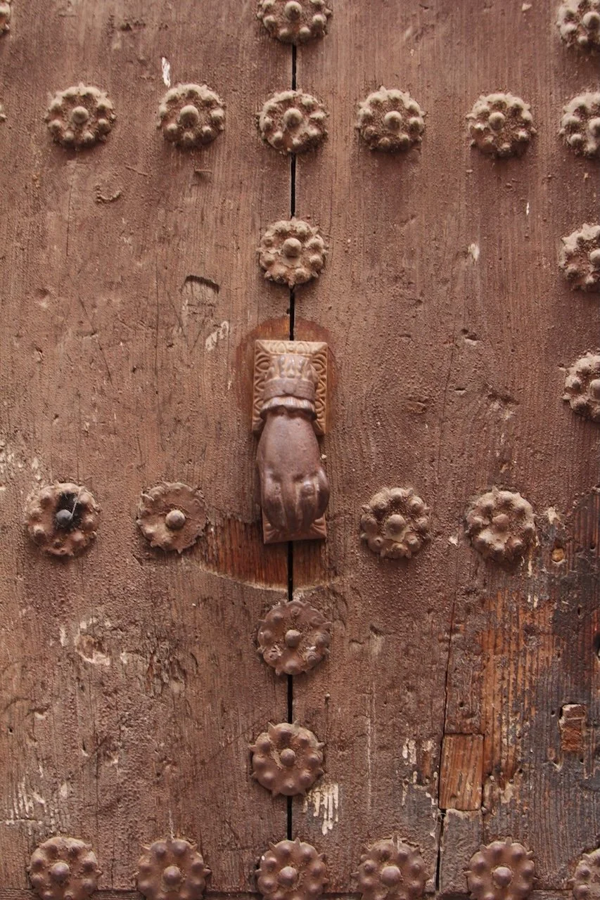 Brown studded door with hand knocker