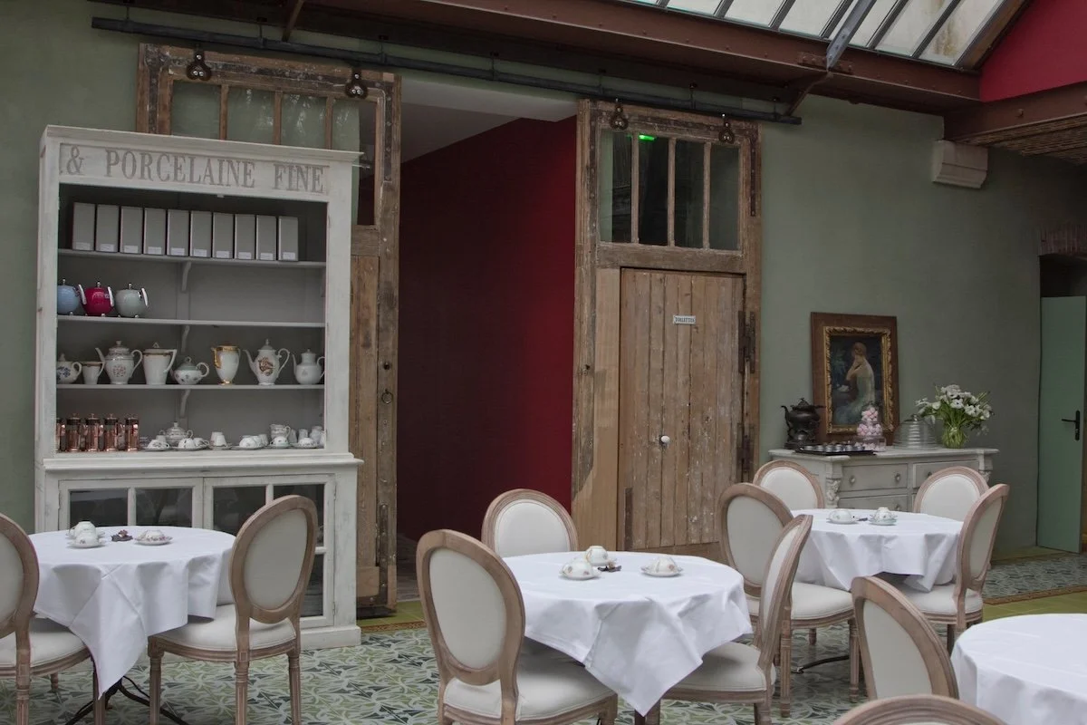 Tea-room with tables laid with white tablecloths and crockery