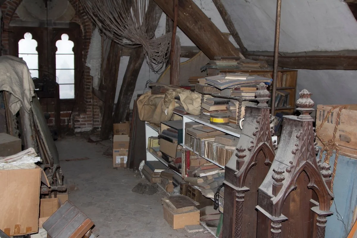 A dustry attic filled with books on shelves