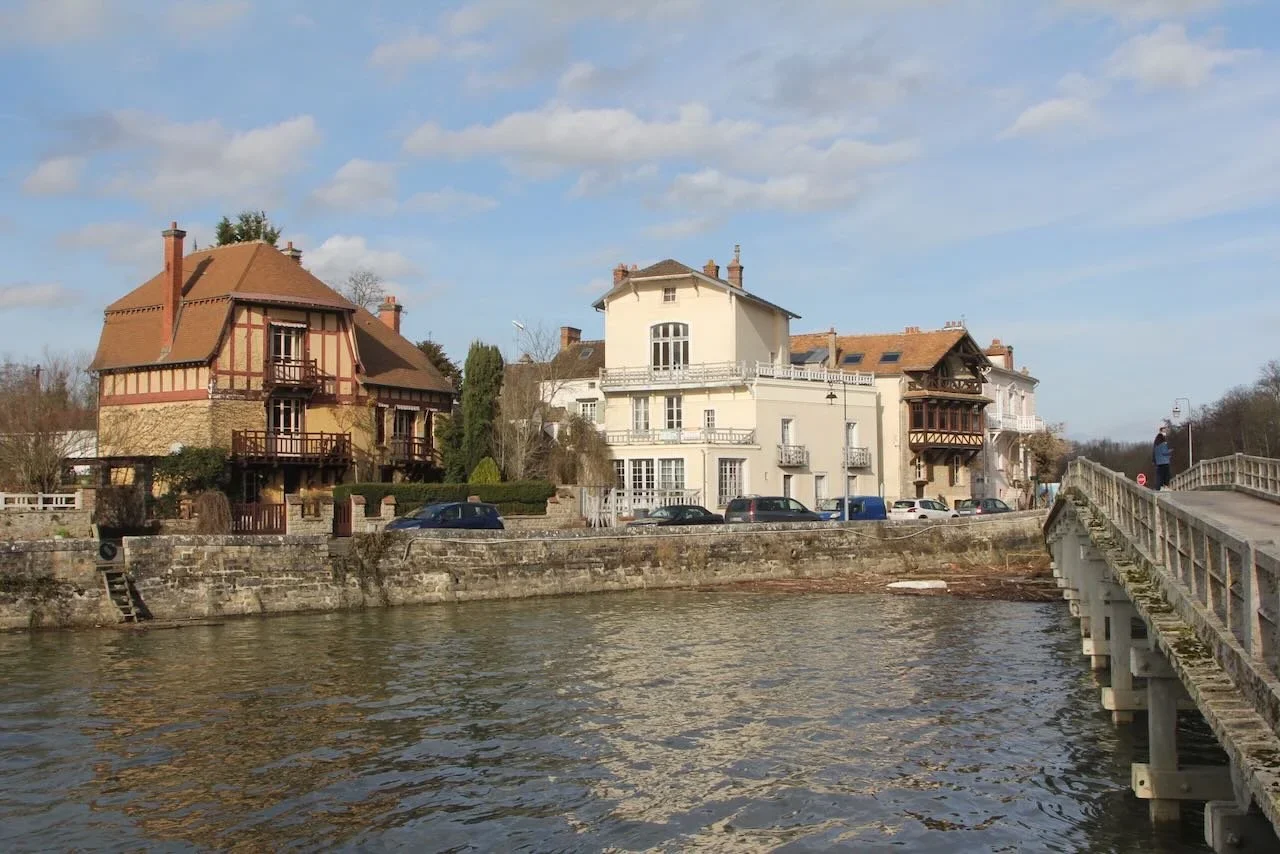 River with houses and a pedestrian bridge