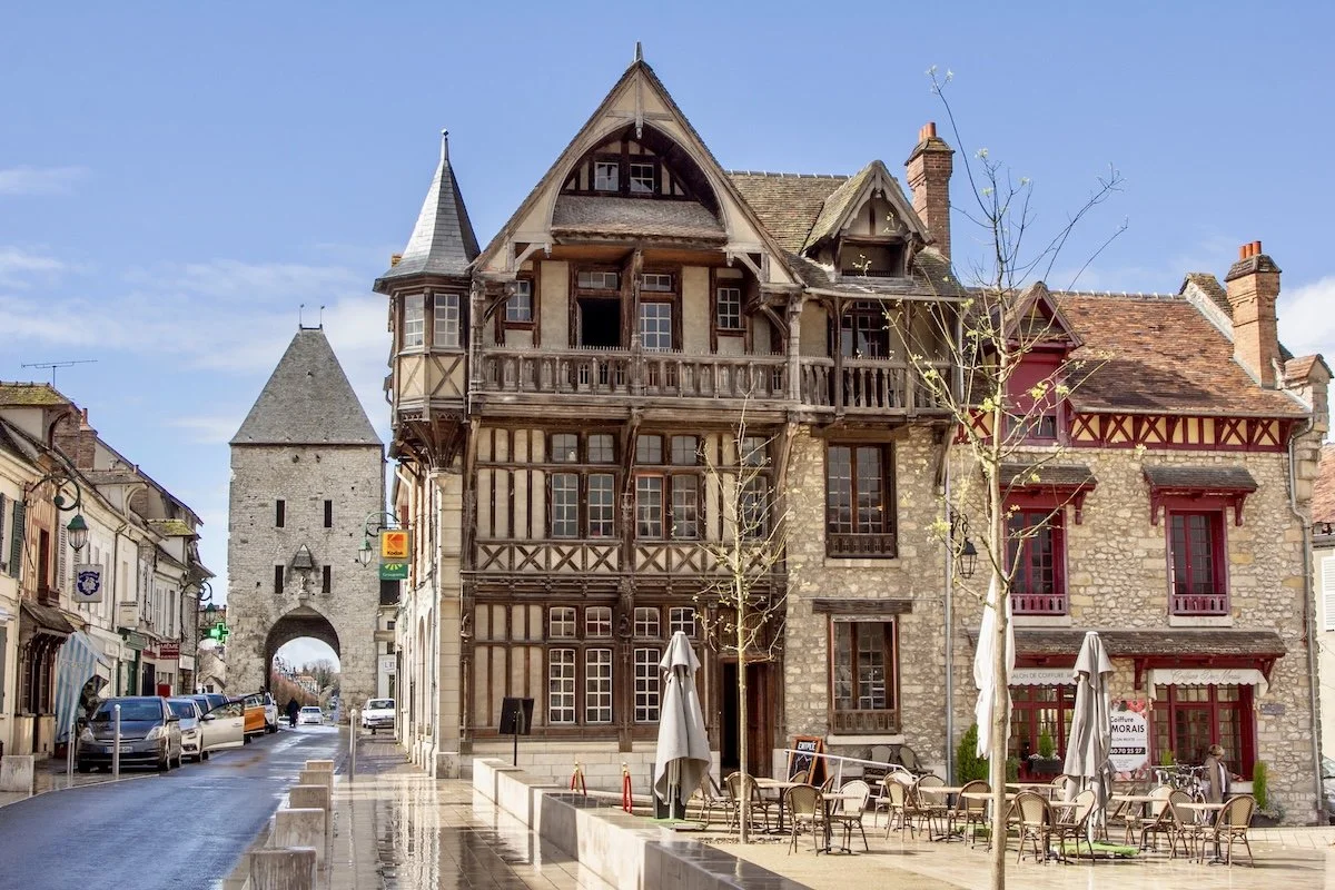Half-tiombered house and medieval city gate on sunny day