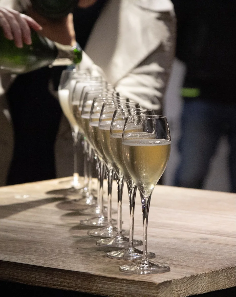 row disappearing into background of filled champagne glasses