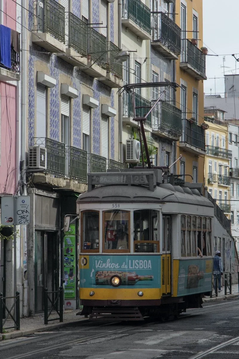 Old tram train in front of colourful buildings