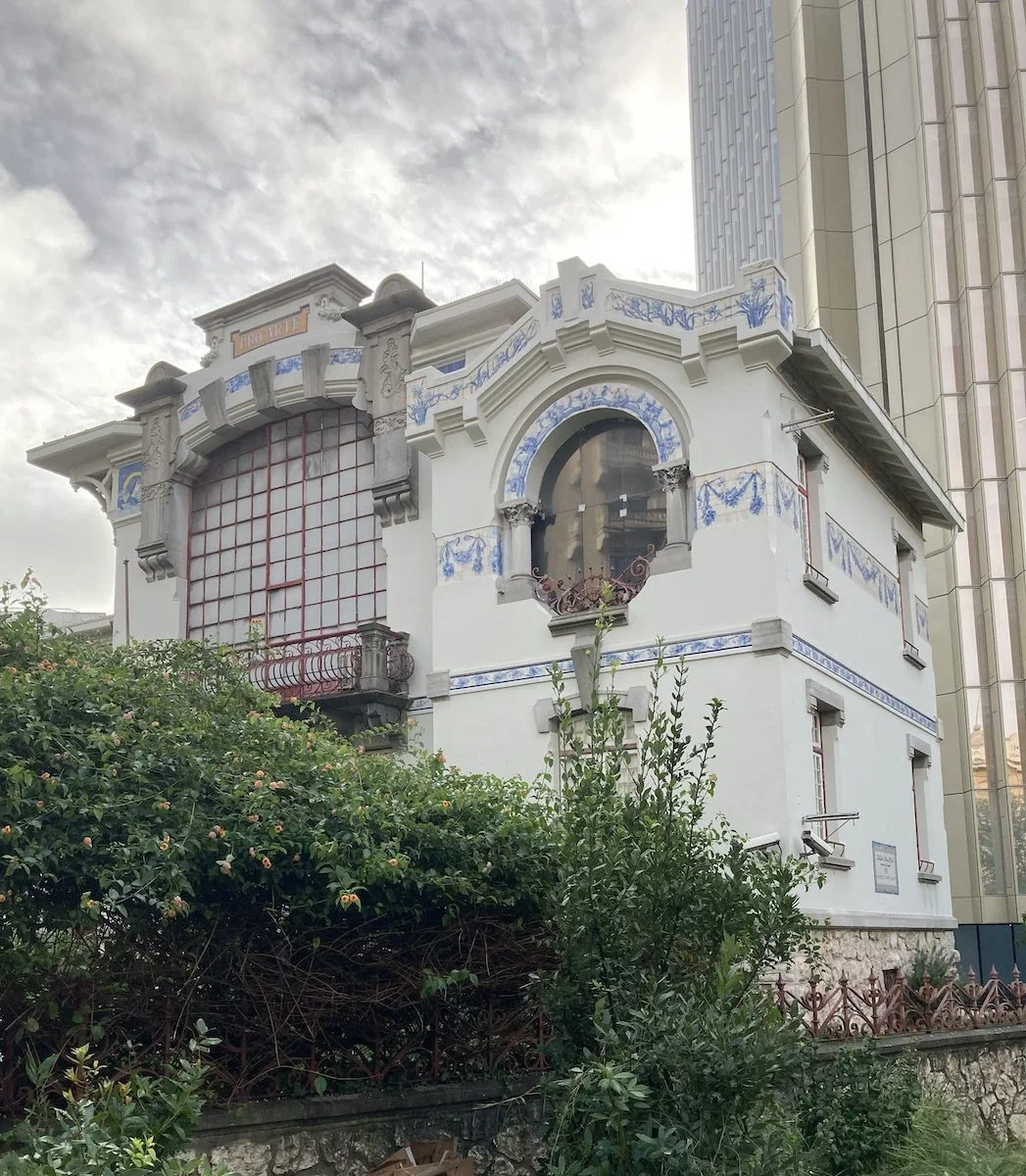 Art Nouveau white house with large windows and blue decorations