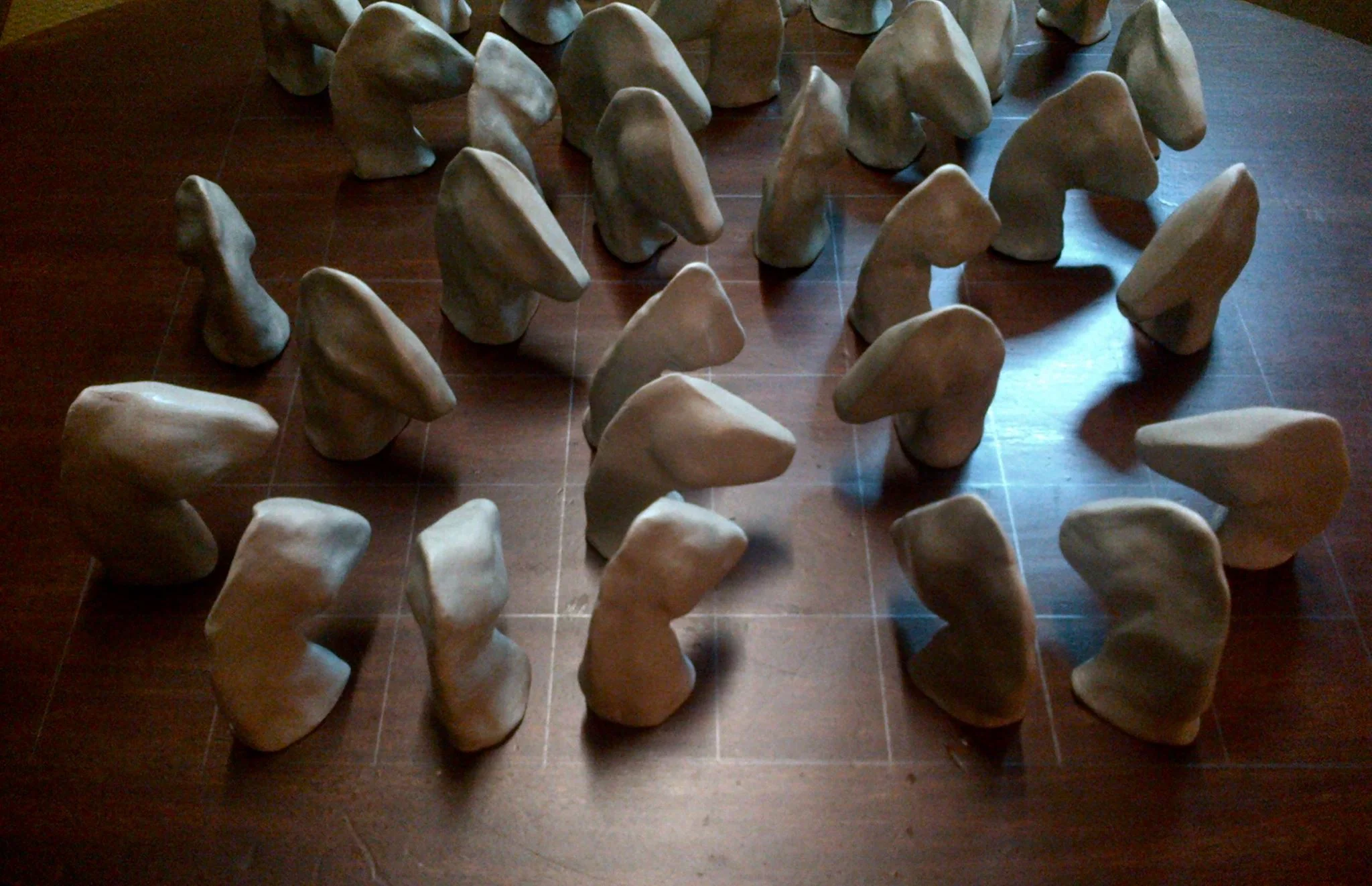 Stud chess, 2014, burnished air dried clay on pencil grid on wooden table
