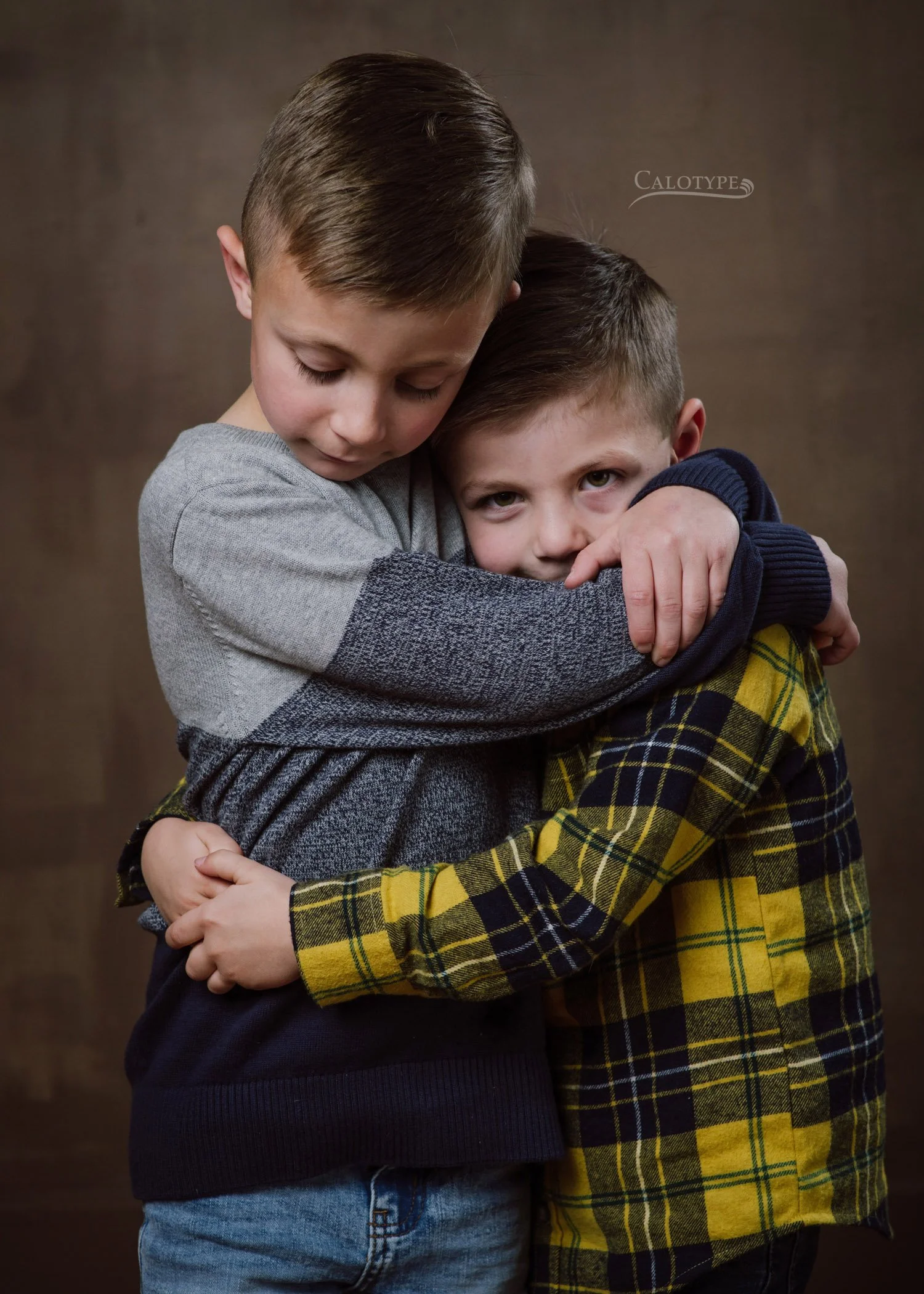 vertical color photo of  brothers hugging sweetly