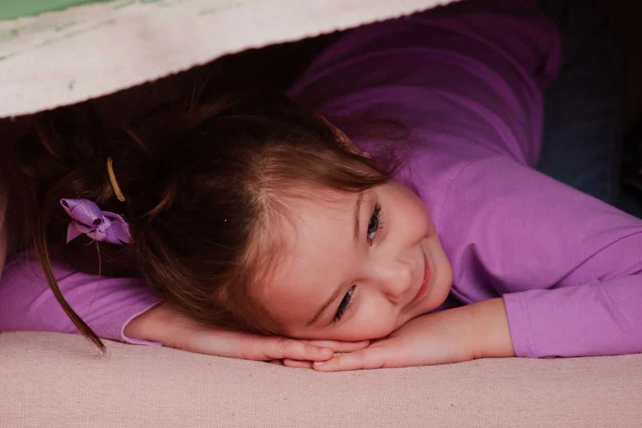 Big sister had some pose ideas of her own.  I had some folded canvas backgrounds draped over this chair I wasn’t using.  She crawled inside to make a little nest. :)