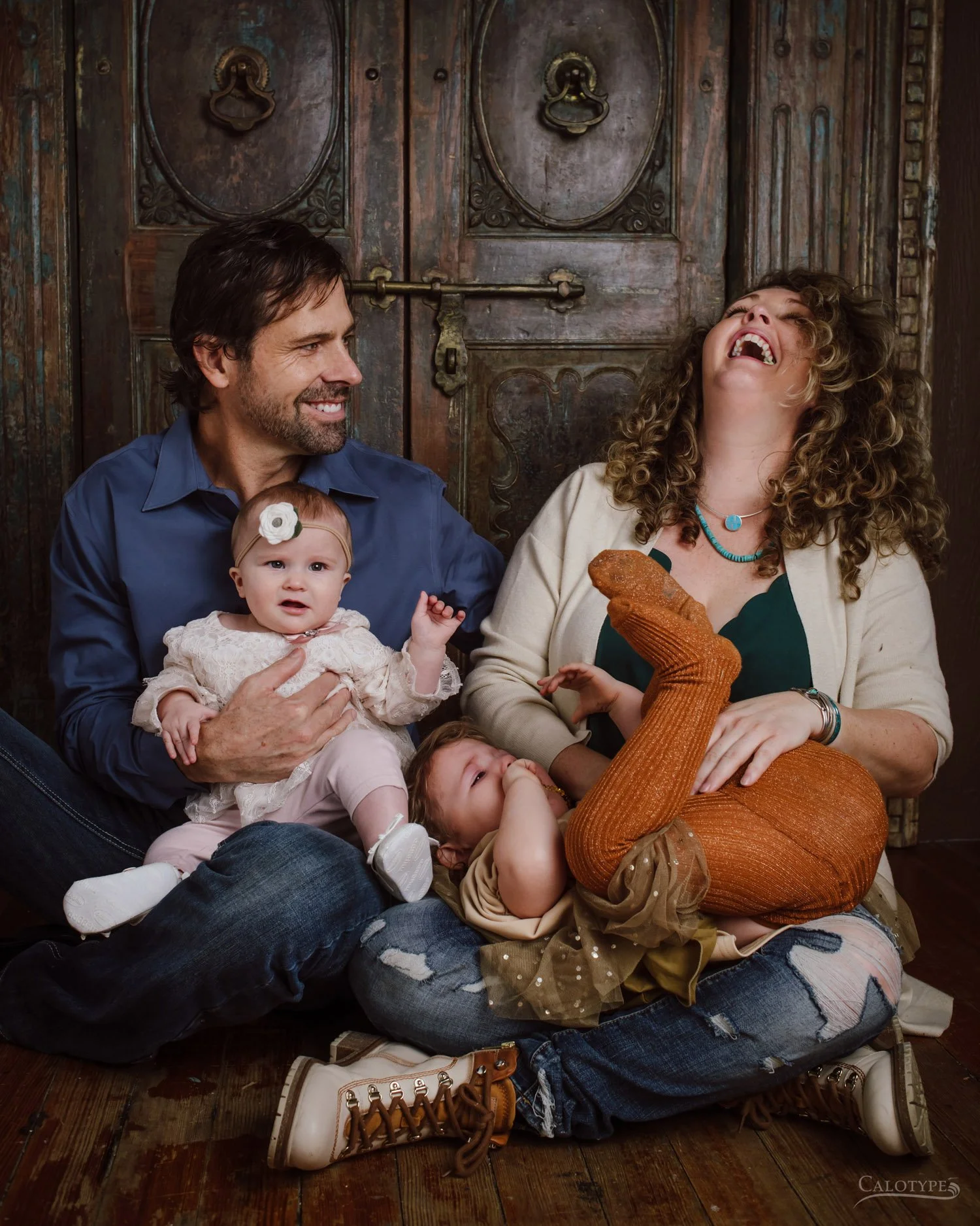 Fun family photo of parents laughing with small kids