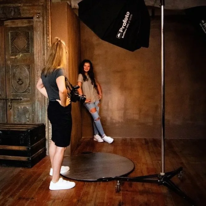 Photographer Julie Stephens shows a teenage girl how to pose for pictures in the studio
