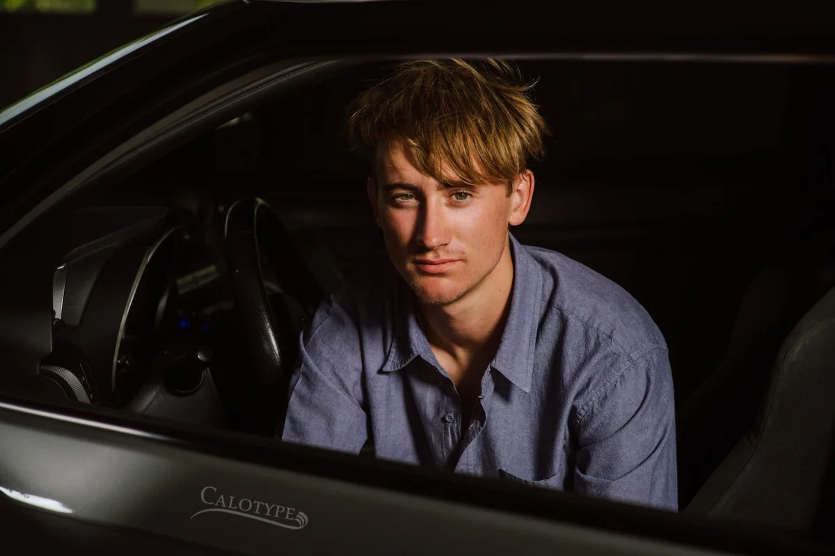 trendy photo of a high school senior boy in his car for senior pictures