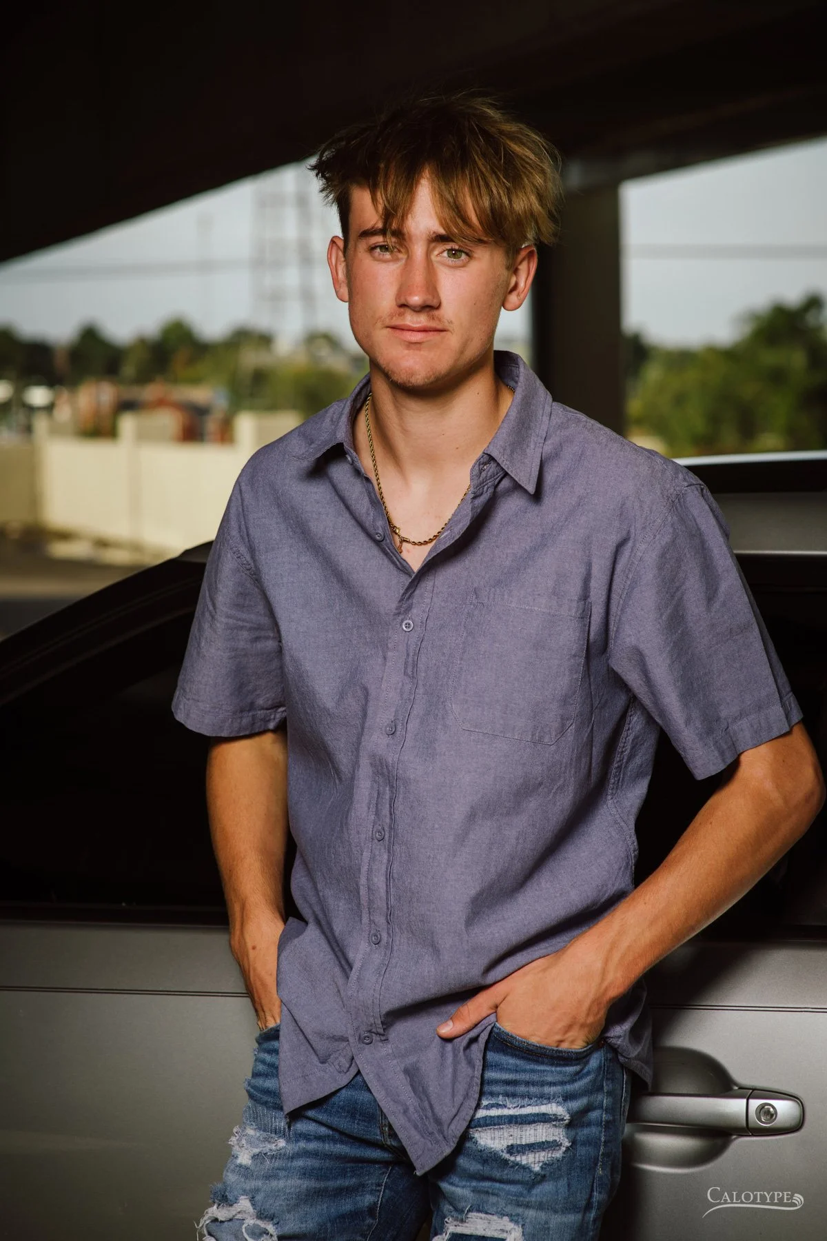 high school senior boy photoshoot, leaning against his car and looking directly at camera