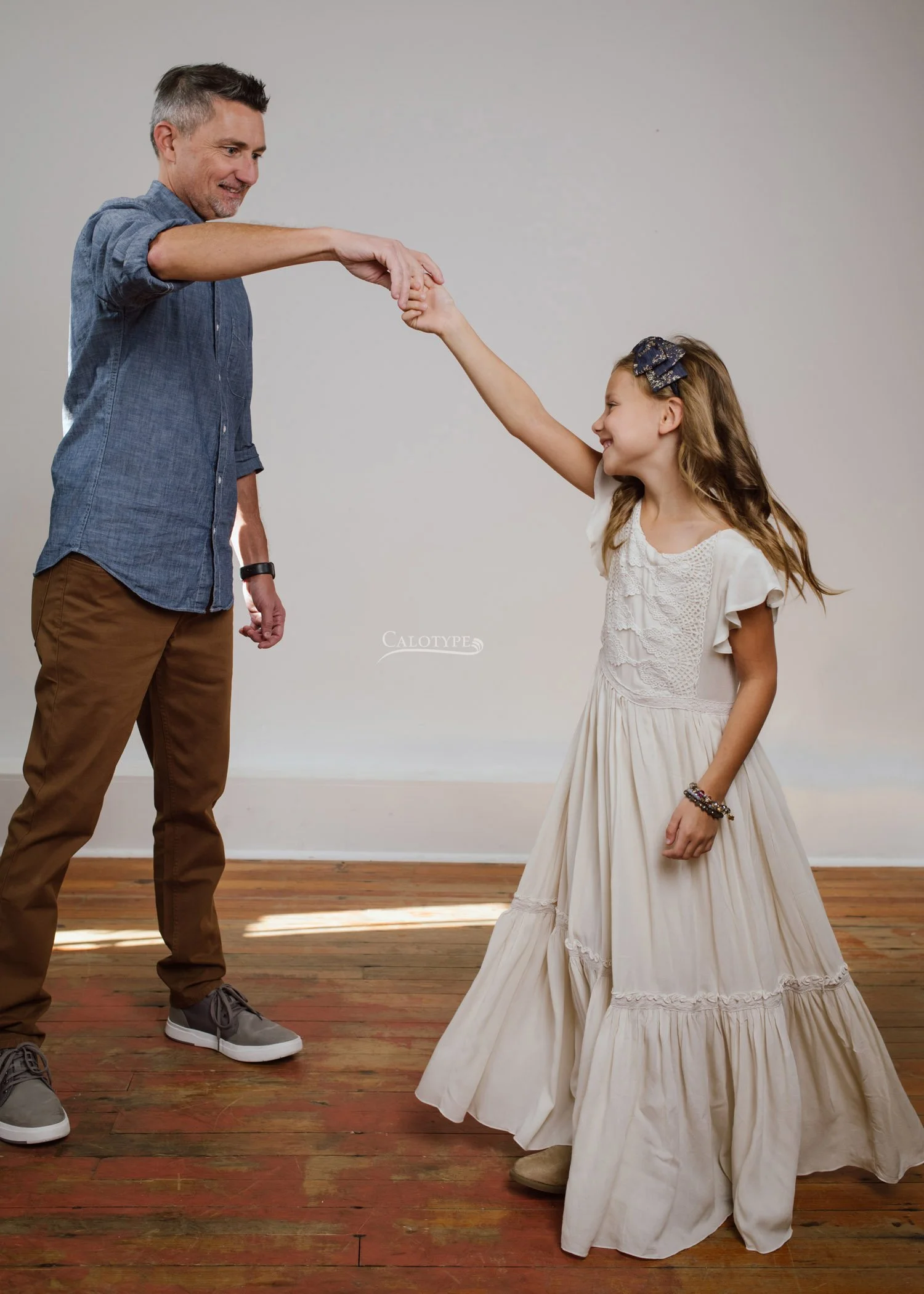 Dad dancing with his 7 year old daughter for a photoshoot in the studio