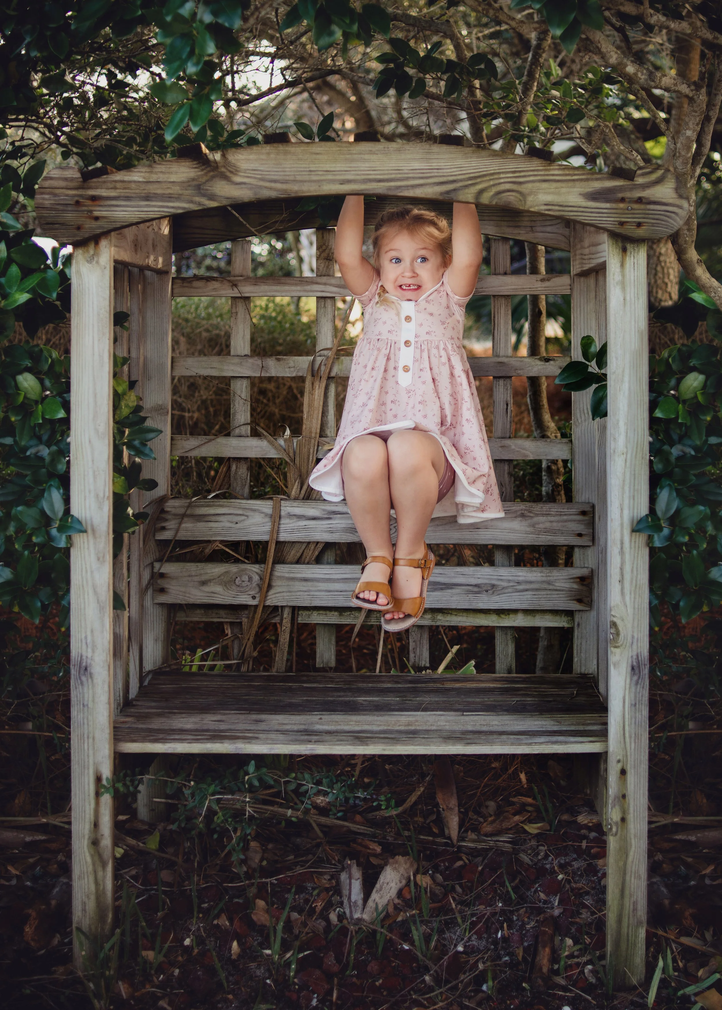 four year old girl in braids plays on bench in Destin