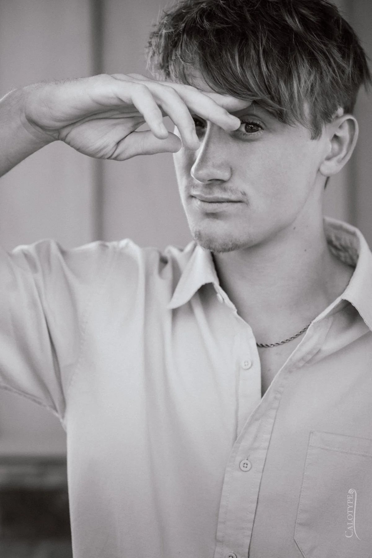 black and white trendy picture of senior boy pushing the hair back from his eyes