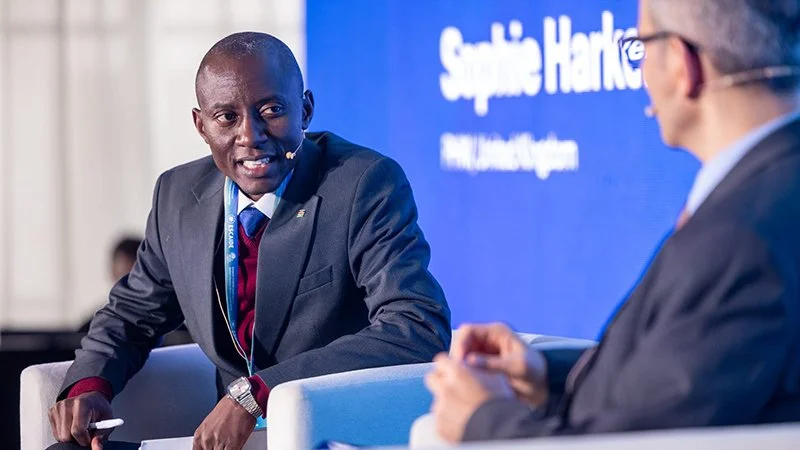 Man with microphone speaking on stage to another man