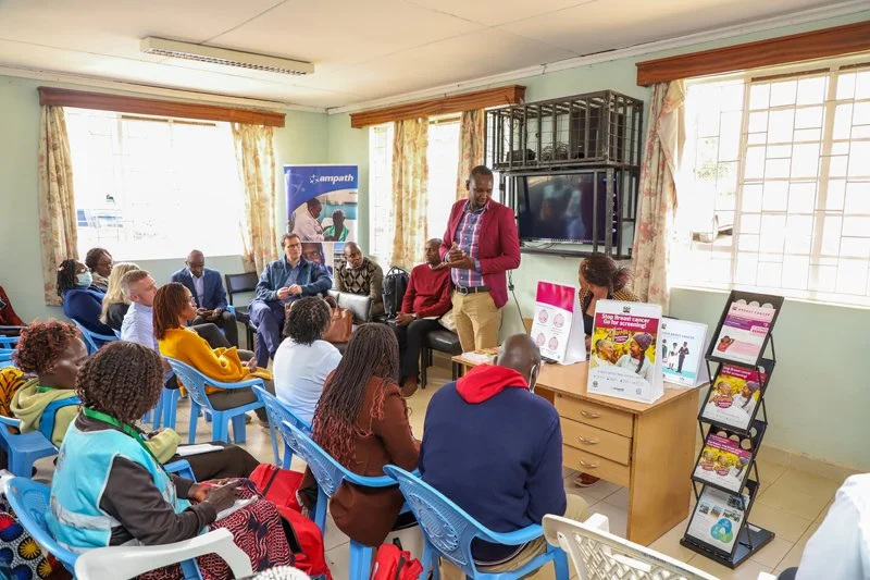 Man stands in front of a room full of people giving information
