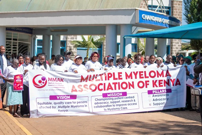 Many people behind a multiple myeloma banner in front of Moi Teaching and Referral Hospital