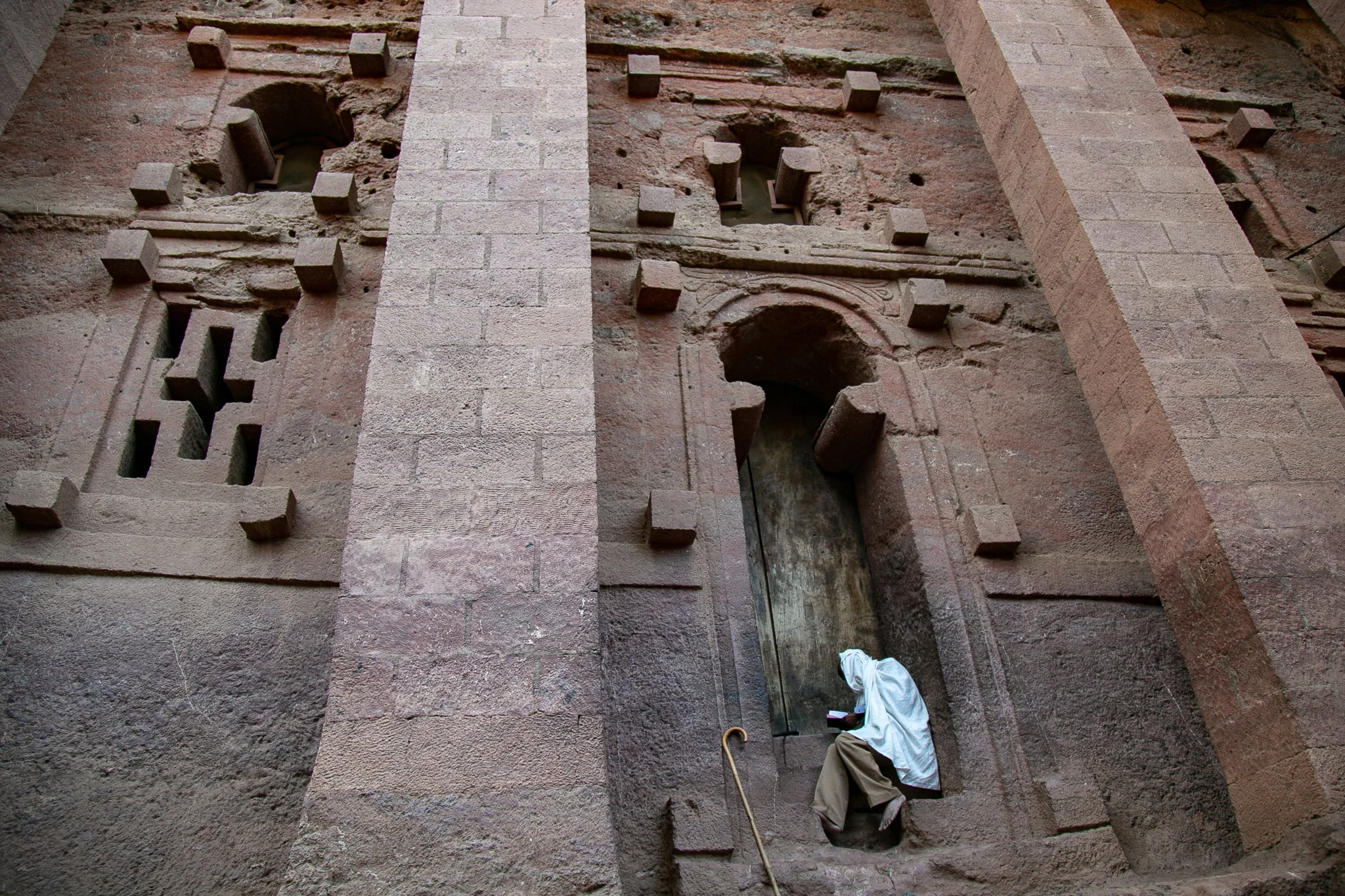 An Ethiopian Orthodox monk quietly reads outside an ancient rock-hewn church in Lalibela, Ethiopia © Kim I. Mott, all rights reserved