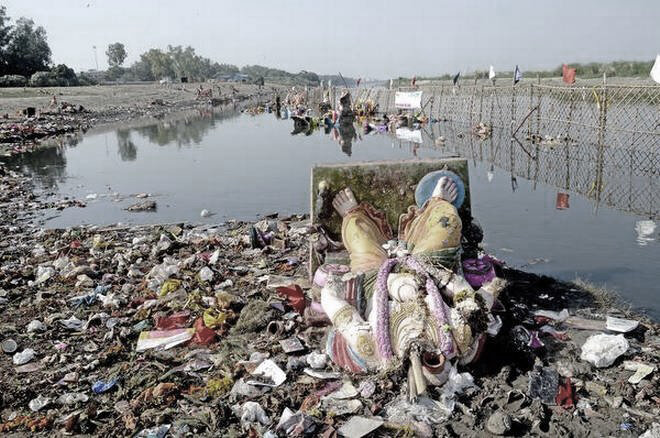  Damaged idol lying along with miscellaneous trash on the banks of Yamuna.  