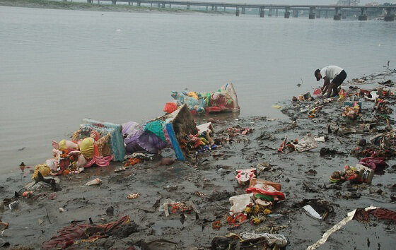  Worker trying to clean up the bank of river post immersion activities 