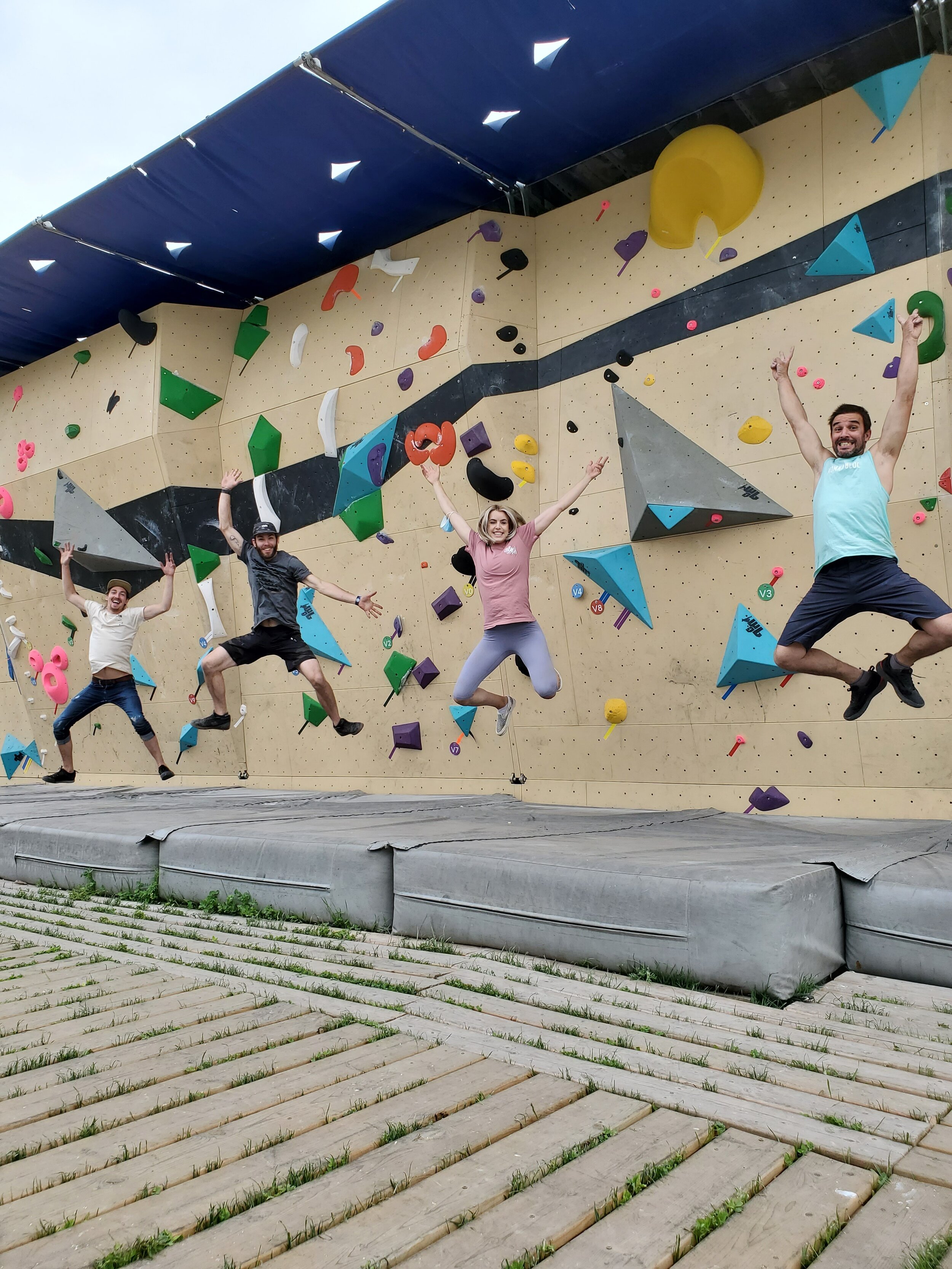 Plusieurs personnes heureuses devant un mur d'escalade 