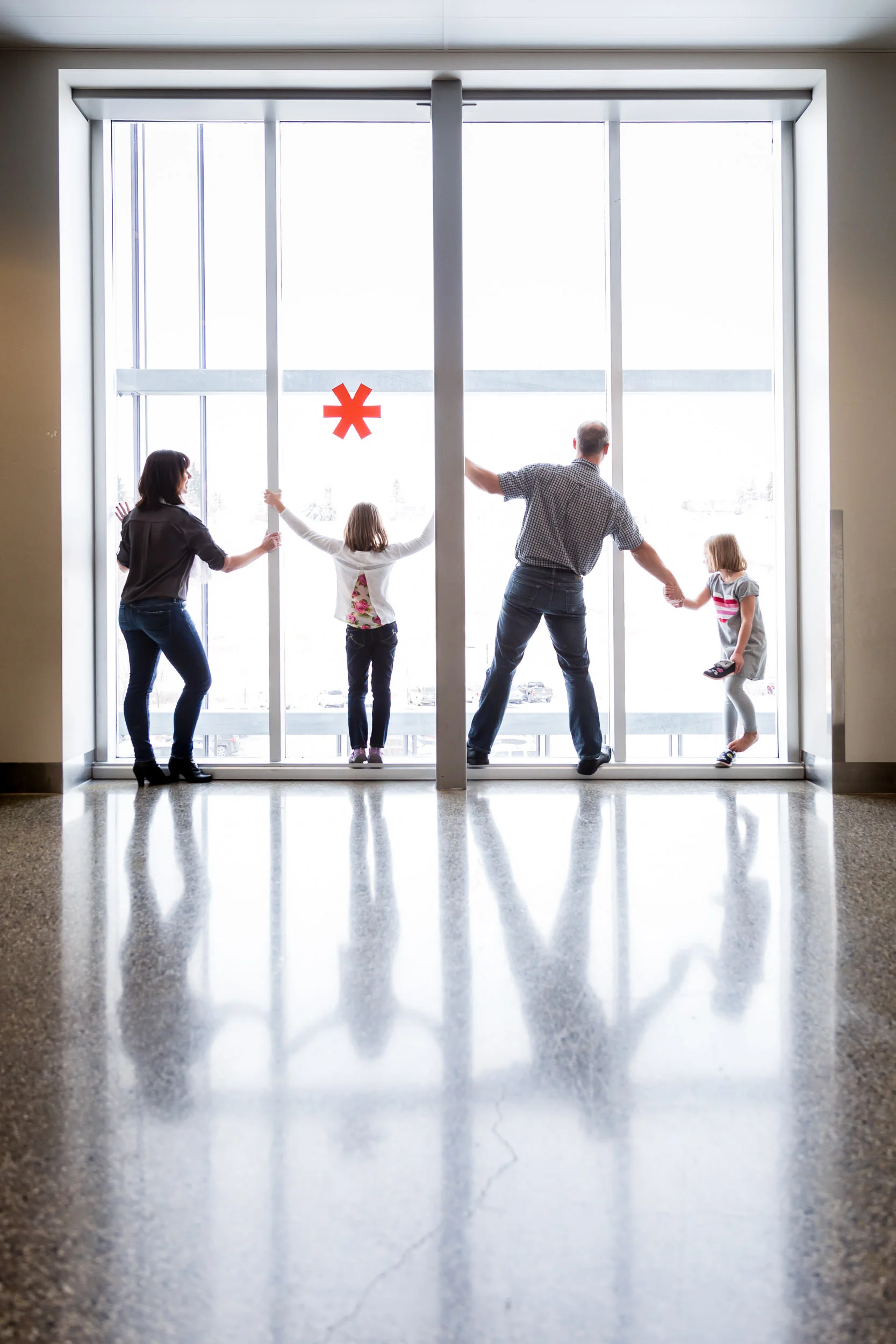 family_of_four_framed_in_window_of_calgary_science_museum_by_Hunnicutt_Photography.jpg