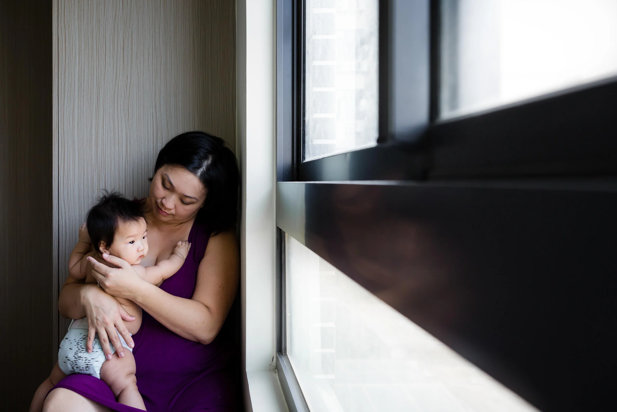 mom_in_purple_holds_baby_by_window_by_Hunnicutt_Photography.jpg